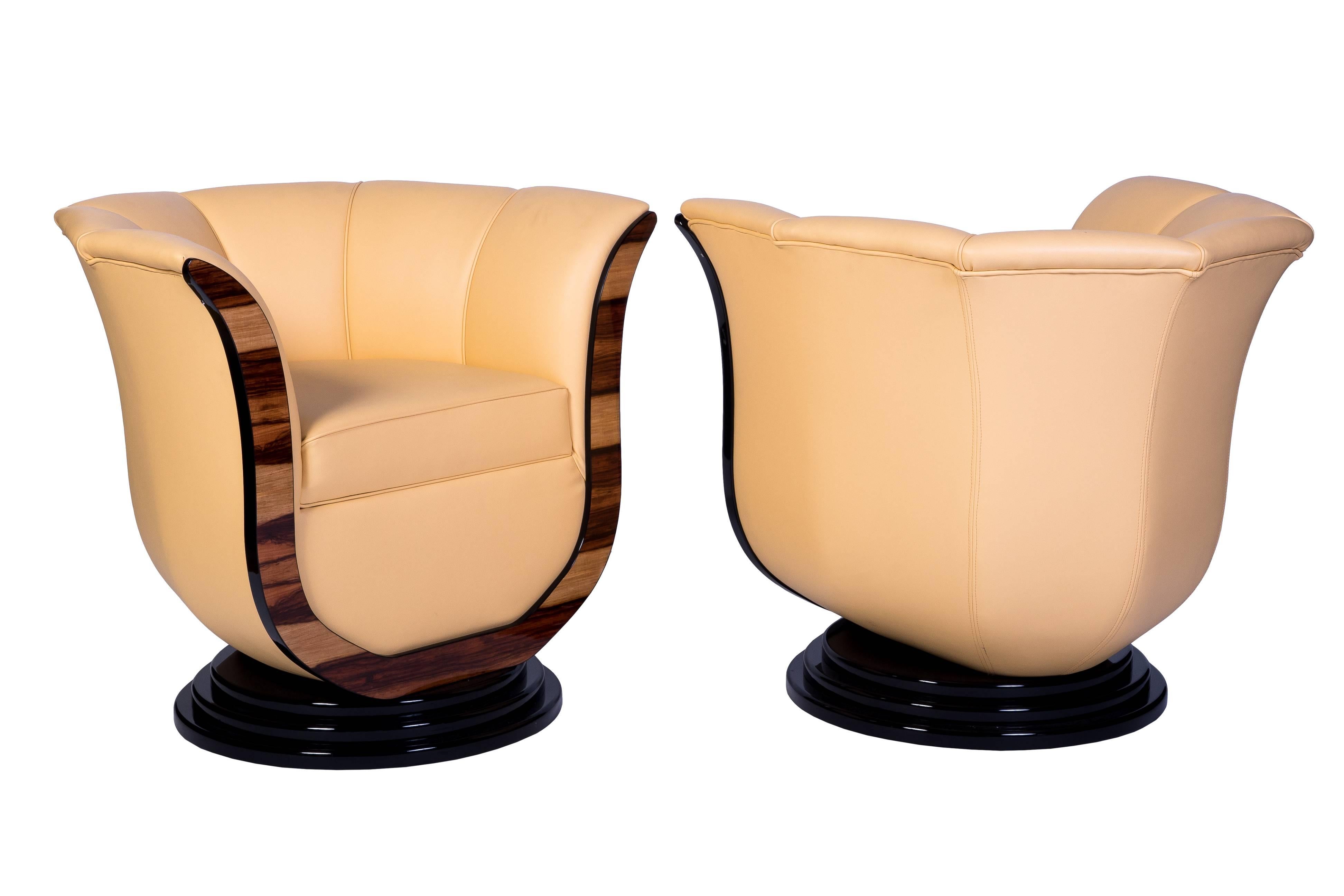 This superb pair of Art Deco style tulip armchairs feature a tulip form design in a luscious cream leather upholstery, and a high gloss lacquer finish and stair foot base in black.