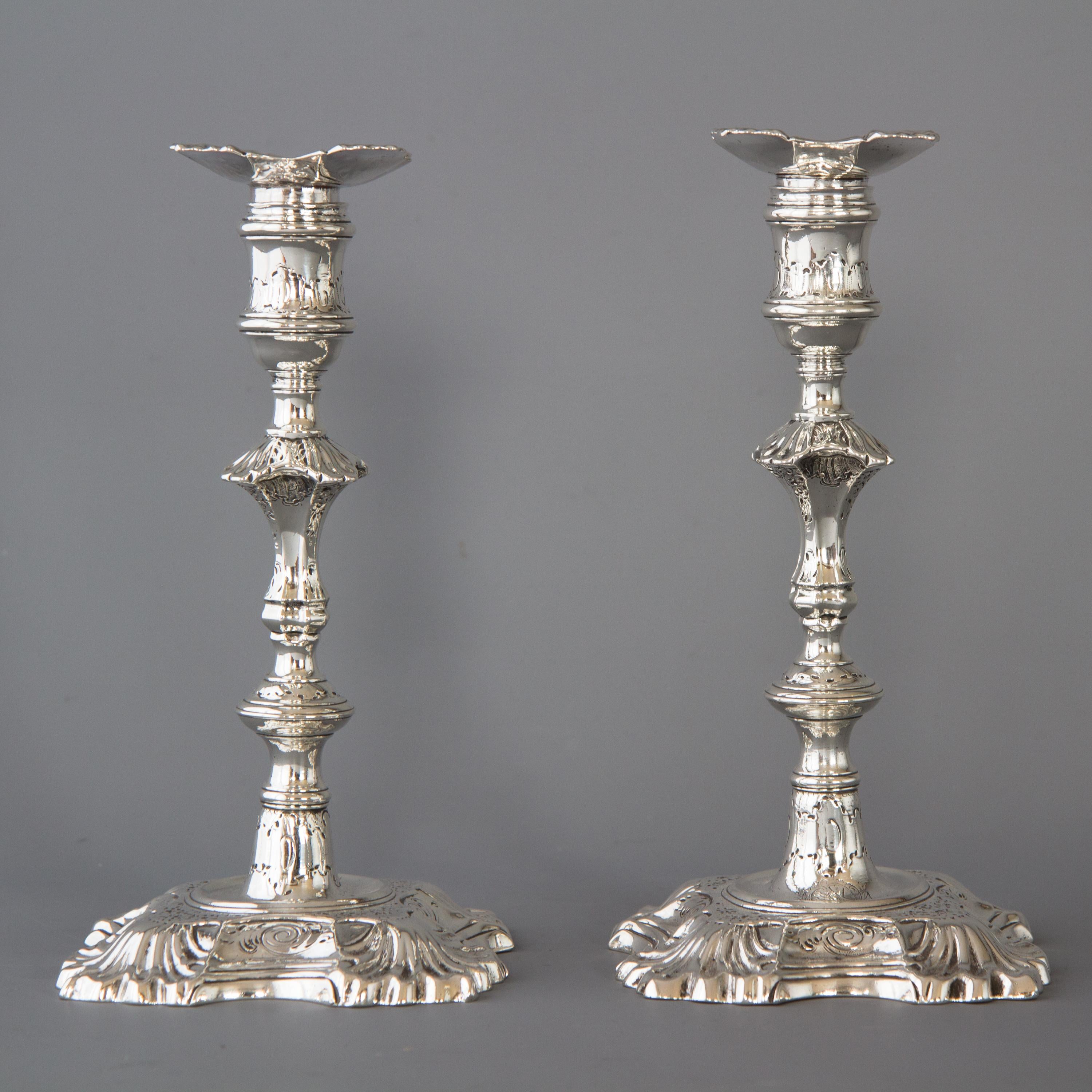 A superb pair of cast George II silver candlesticks by John Cafe, London 1749. With square bases shaped and stepped with acanthus form corners. The fluted columns rising above a circular knop to a square knop with matching acanthus decoration to the