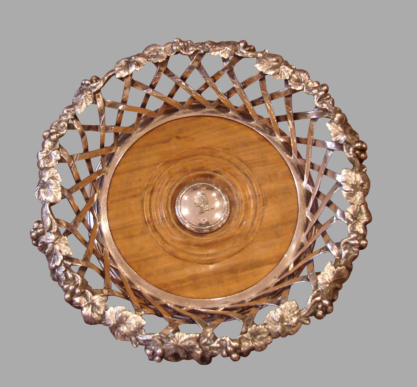 A superb and elegant pair of Elkington and Company silverplate decanter coasters of large scale, each with a foliate vine and grape decorated rim, above a lattice designed side, framing turned walnut bases with central bosses engraved with an