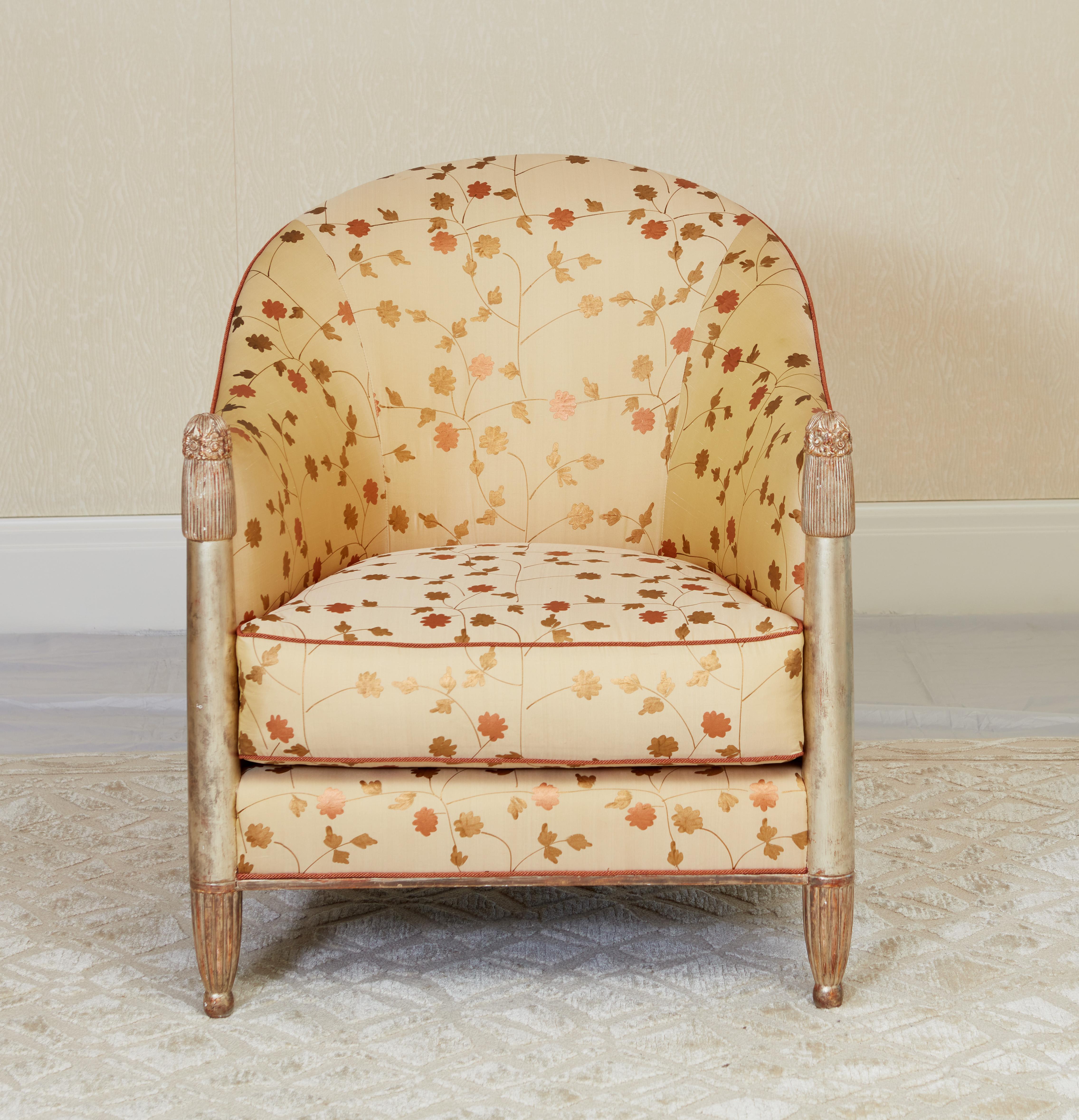Una superba coppia di poltrone francesi Art Déco dorate in oro bianco, ciascuna progettata con uno schienale profondamente curvo. I sostegni anteriori presentano un disegno floreale finemente dettagliato su una sottile scanalatura, il tutto su piedi