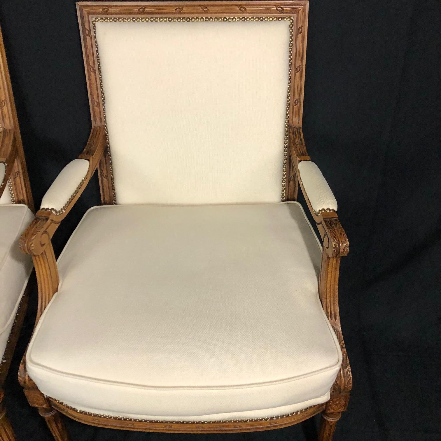 Sublimely elegant pair of 20th century Italian carved armchairs or bergeres in the style of Louis XVI, complete with brass tacks and crisp new ivory upholstery. #1241.

 
  