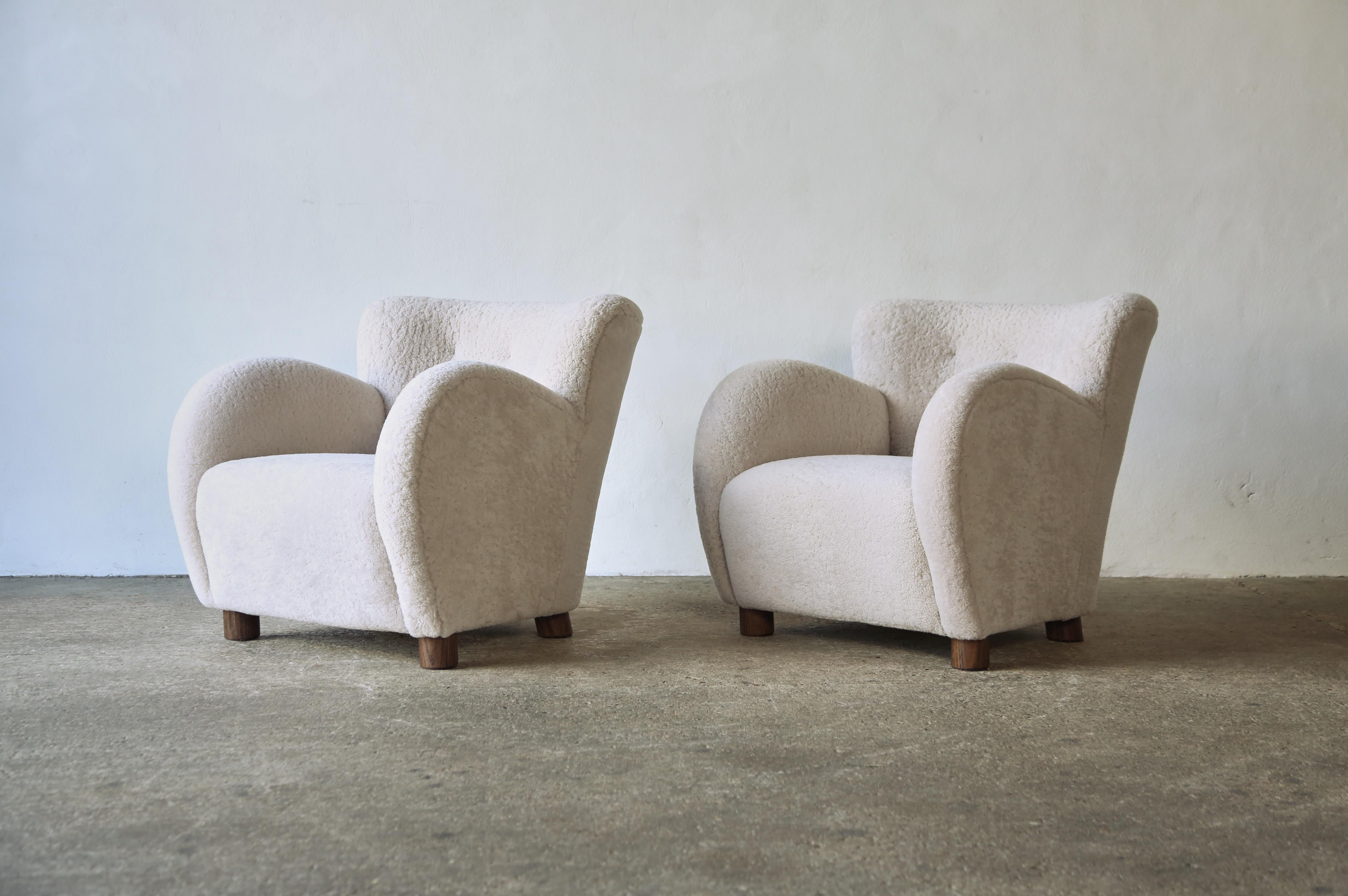 A superb pair of modern round-arm lounge chairs.  Handmade beech frames, sprung seats, with solid oak feet.  Newly upholstered in premium, soft, natural Australian sheepskin.  Fast shipping worldwide.


