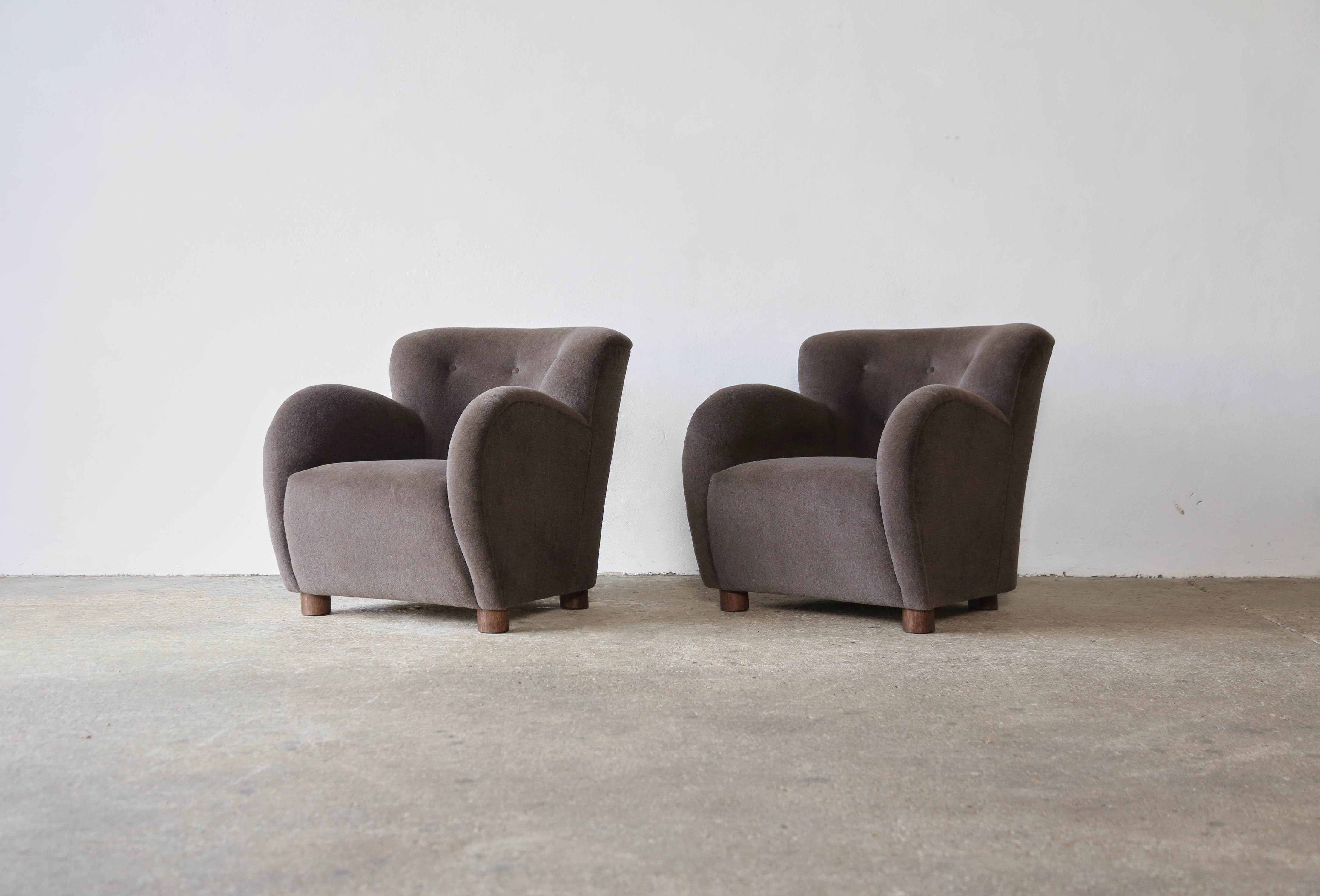 Superbe paire de fauteuils modernes à accoudoirs ronds de style danois. Structure en hêtre fabriquée à la main, assise à ressorts et nouvellement recouverte d'un tissu en pure laine d'alpaga doux et de première qualité, pieds en chêne massif.