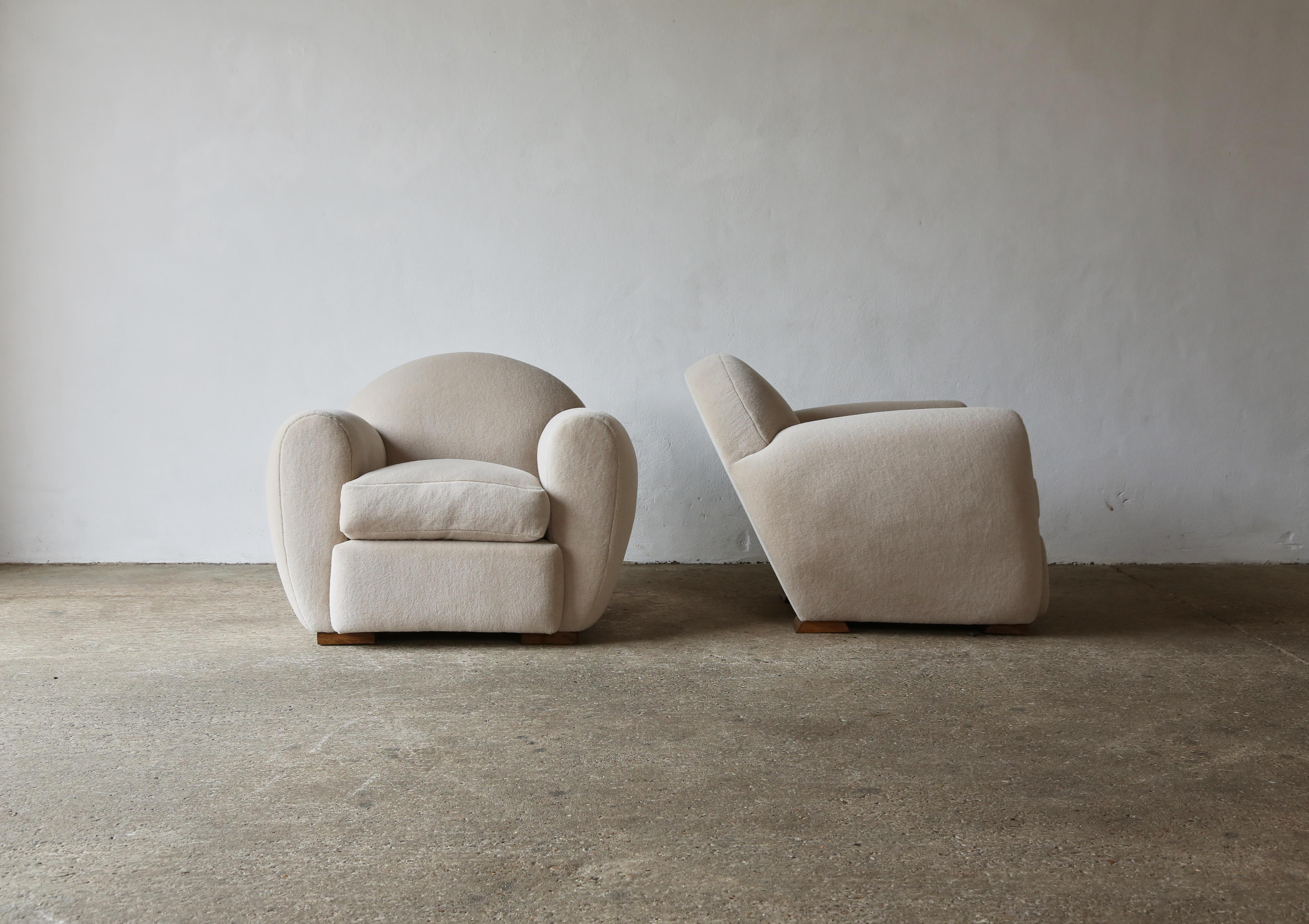 Superbe paire de fauteuils club modernes, ronds et inclinés, revêtus d'Alpaga pur.  Cadre en hêtre de haute qualité fabriqué à la main et nouvellement tapissé d'un tissu doux, ivoire, 100% laine d'alpaga de première qualité.   Fabriqué à la main en