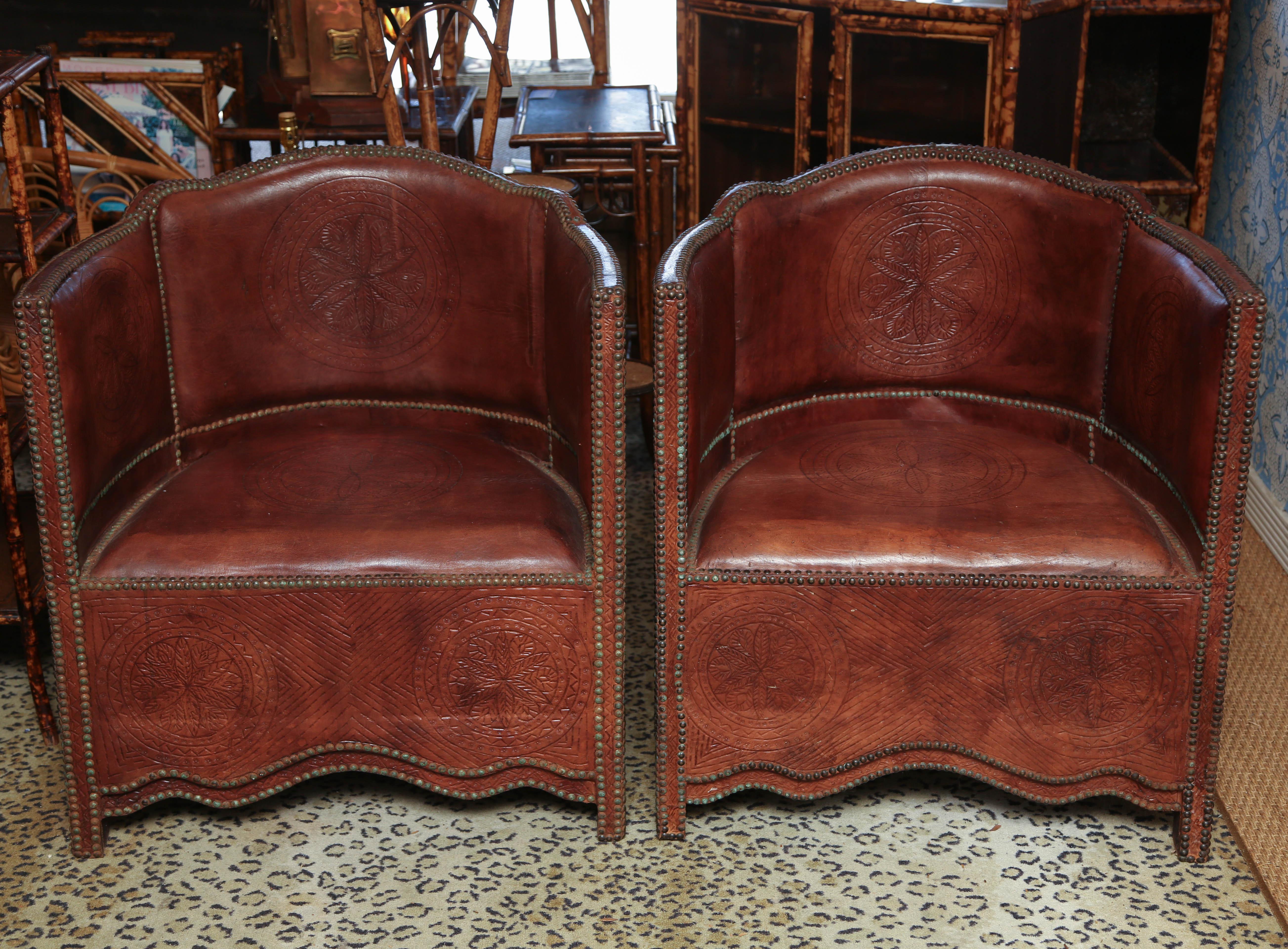 Made with hand tanned hand tooled leather in Morocco, showing the natural imperfections in the leather. These chairs are vintage, circa 1960 as evidenced by the wear and tarnishing on the brass nail heads. Beautifully handcrafted and decorated,