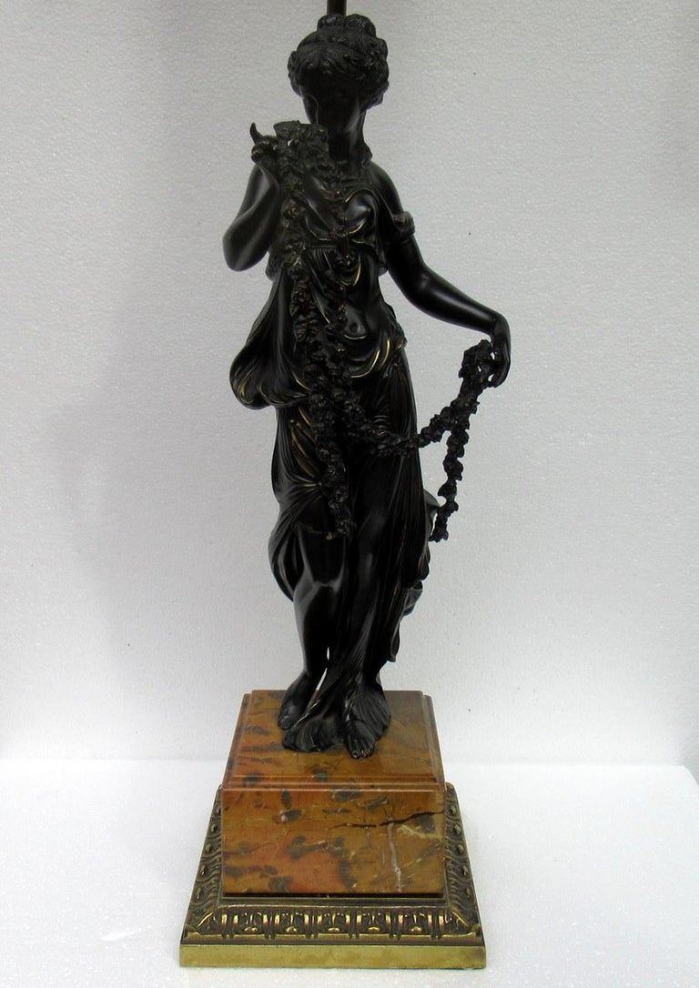 An exceptionally well cast dark patinated bronze figure modelled as a standing classical female, draped in robes and holding long garlands of flowers. Third quarter of the 19th century, possibly of French origin.

Professionally adapted as an