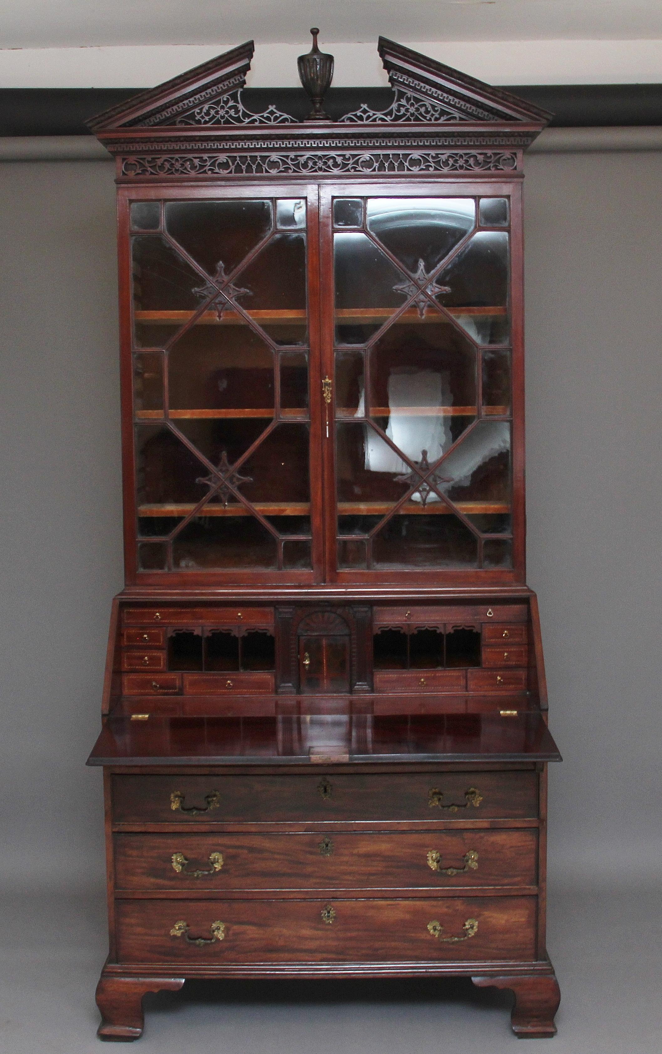 A superb quality 18th century mahogany bureau bookcase, having a wonderful pierced broken arch pediment with a decorative turned and fluted finial at the centre above a pierced frieze, the top section having two astrigal glazed doors opening to
