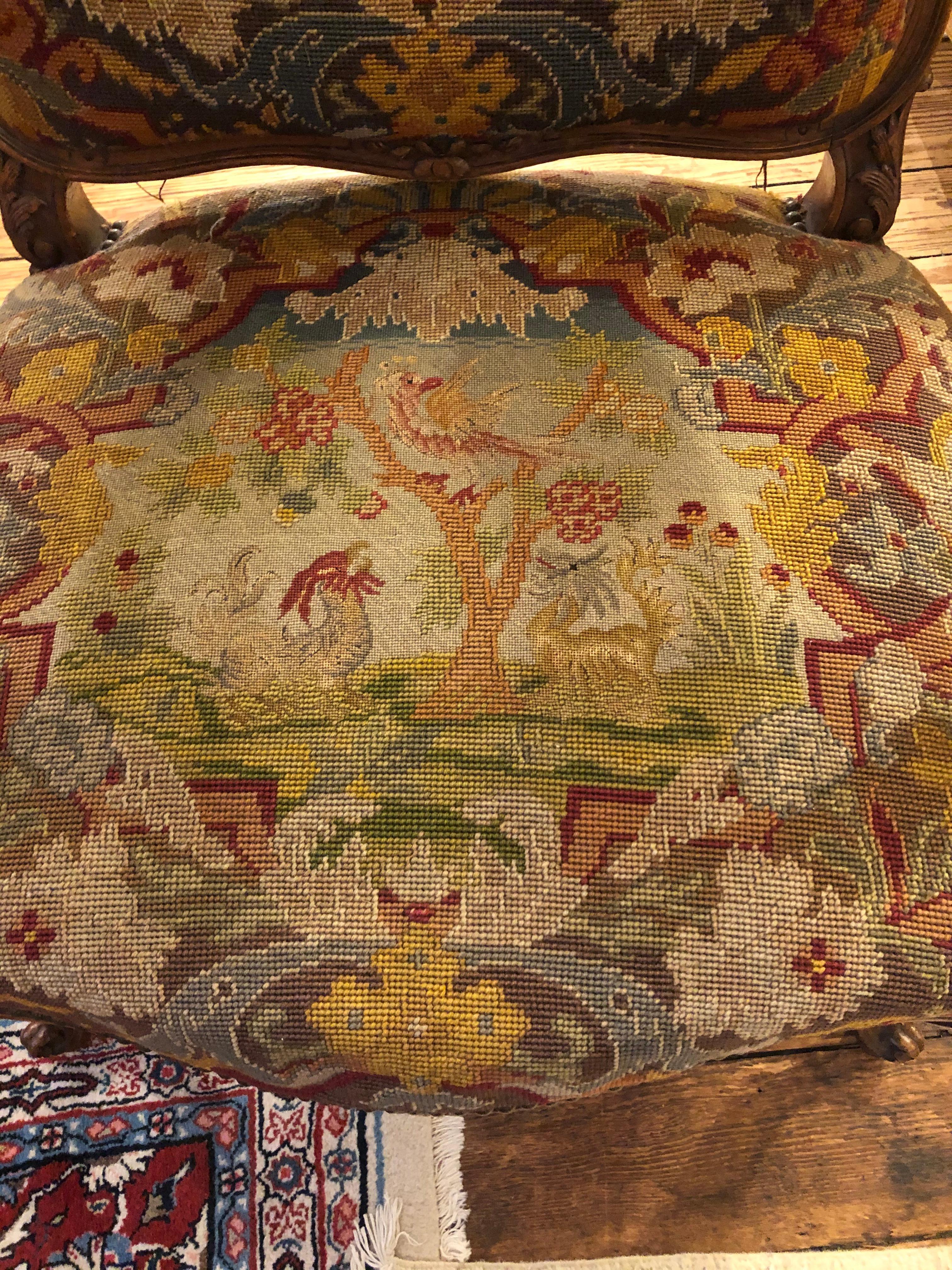 A rare gem found in a large expertly carved walnut Louis XVI armchair with original magnificent figural tapestry upholstery finished with nailheads. The back of the chair is left in worn condition and needs upholstery.
Measures: Arm height 27
Seat
