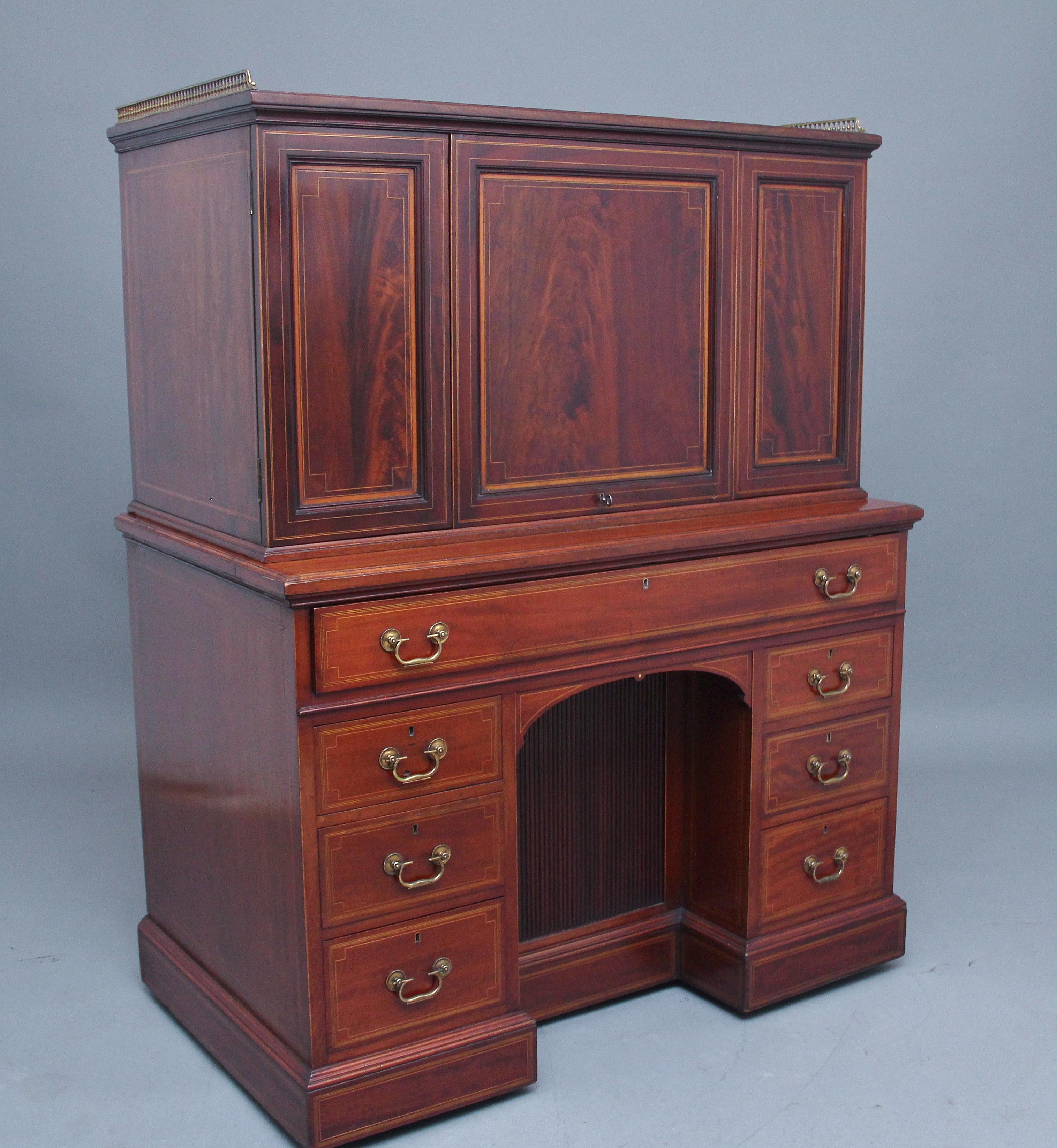 A superb quality 19th century mahogany secretaire desk cabinet, the top section having a brass gallery running along the back and sides, having three moulded and inlaid panels at the front with lovely figuration, the larger middle panel lifting out