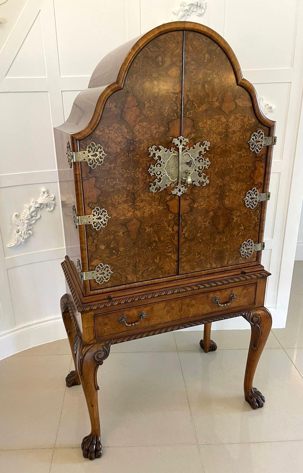 Superb quality antique burr walnut drinks cabinet having a superb quality burr walnut shaped top above a pair of burr walnut shaped doors with original brass hinges and lock plate opening to reveal a fitted interior consisting of a sliding celleret,