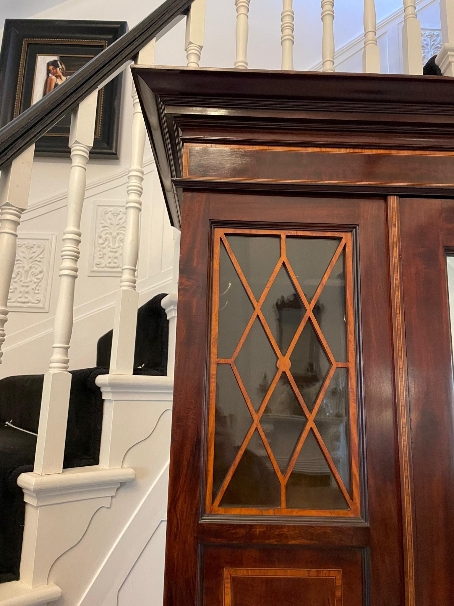 Superb quality antique Edwardian mahogany inlaid wardrobe having a quality mahogany satinwood inlaid cornice above a single mirrored door with a bevelled edge opening to reveal a hanging compartment flanked by a pair of astral glazed panels and a