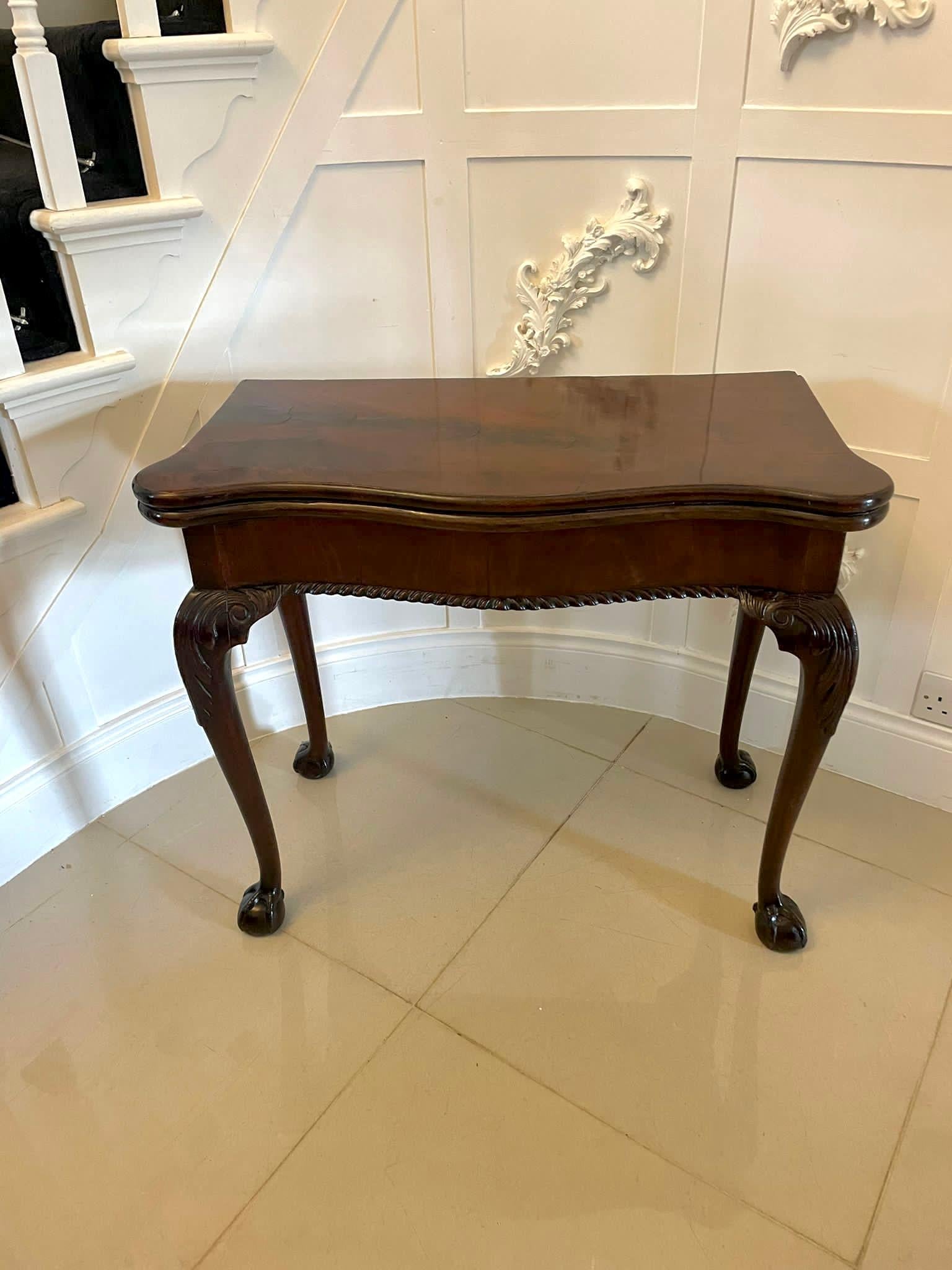 Superb quality antique George III Irish carved mahogany card/side table having a superb quality mahogany serpentine shape fold over top opening to reveal the original baize interior, serpentine shape frieze with a carved edge standing on shaped