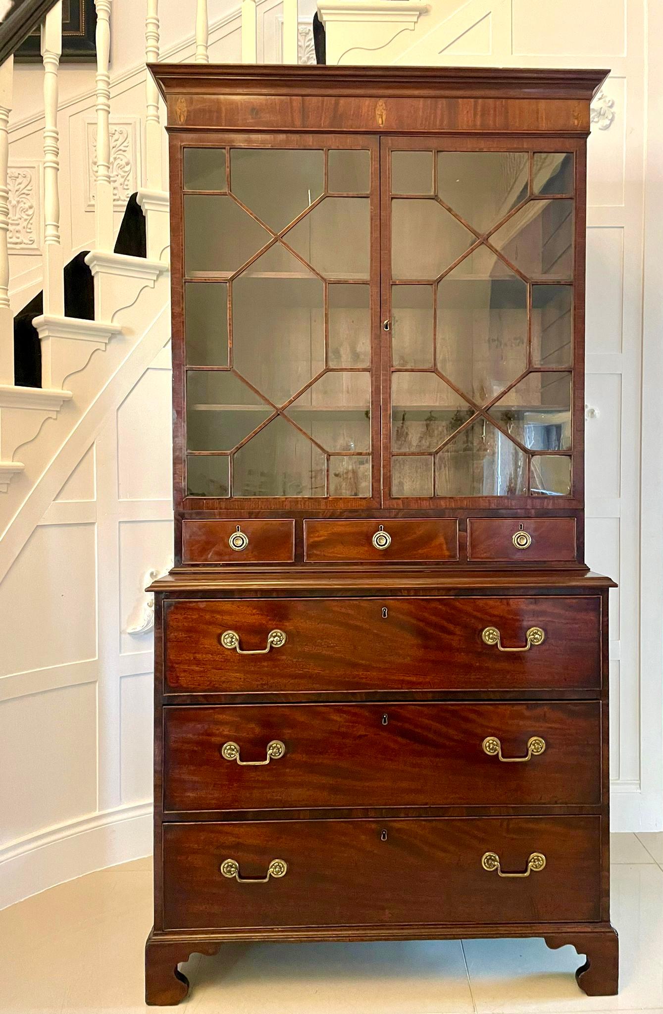 Superb quality antique George III mahogany astral glazed bookcase having a shaped cornice, mahogany frieze with three satinwood inlaid oval patrons above a pair of astral glazed doors with satinwood inlaid stringing opening to reveal two adjustable