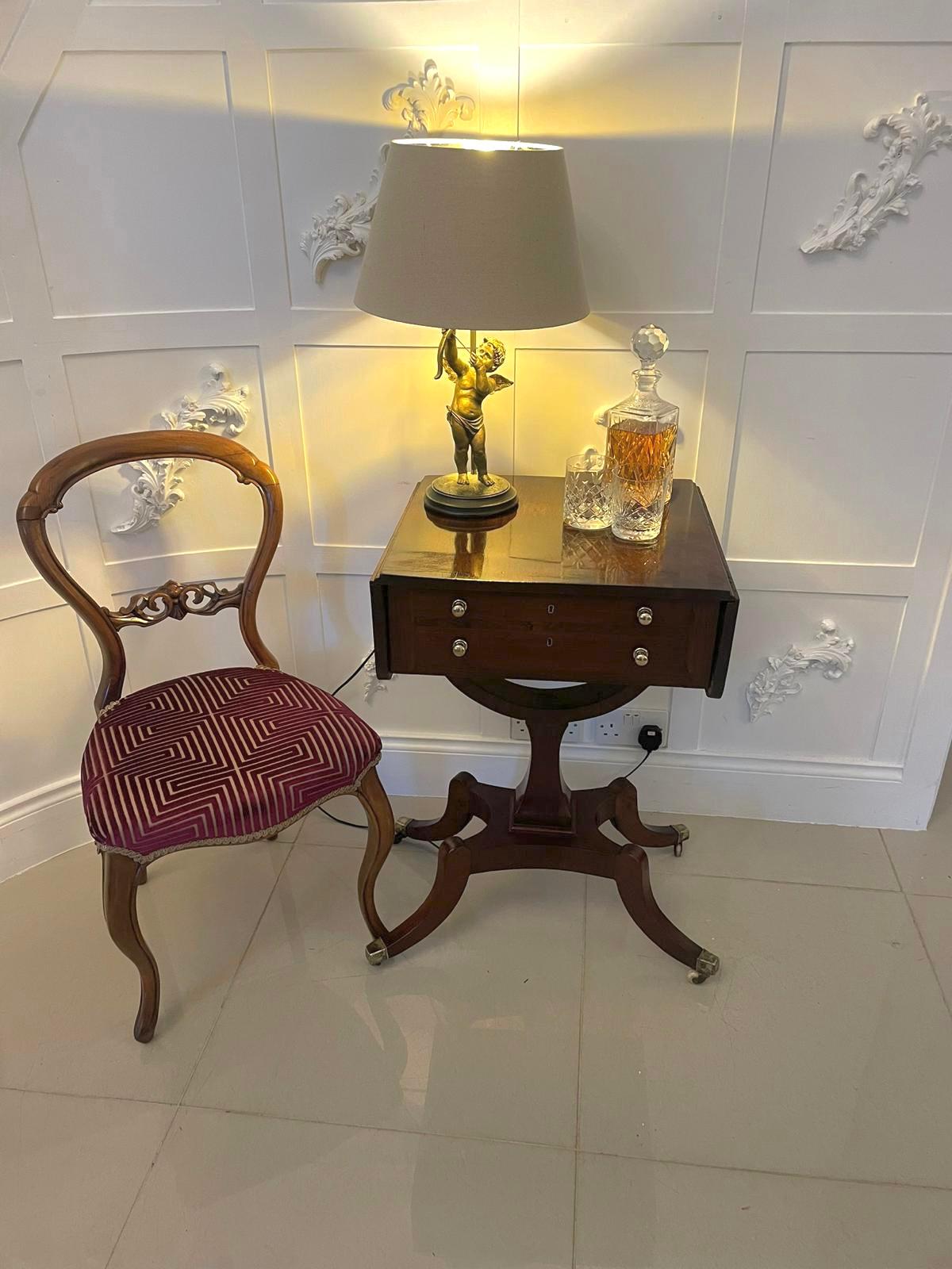 Superb quality antique Regency freestanding mahogany sewing/side table having a quality mahogany cross banded top with two drop leaves above two drawers and two dummy drawers with brass handles standing on shaped sabre legs with brass feet and