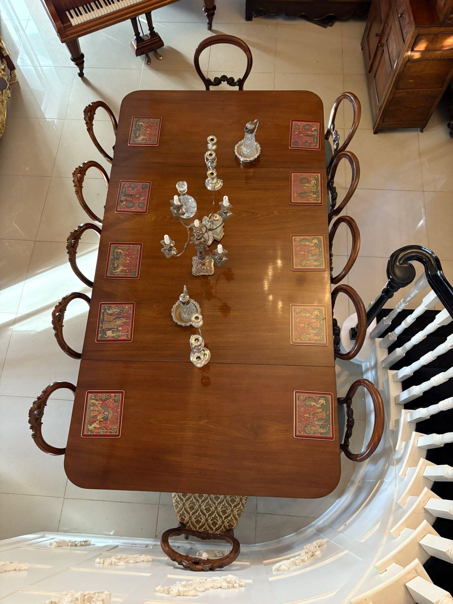 Superbe table de salle à manger Regency à trois piliers en acajou, d'une qualité exceptionnelle et aux proportions généreuses, pouvant accueillir confortablement 12 à 14 convives. La table se compose de deux consoles et d'une longue section