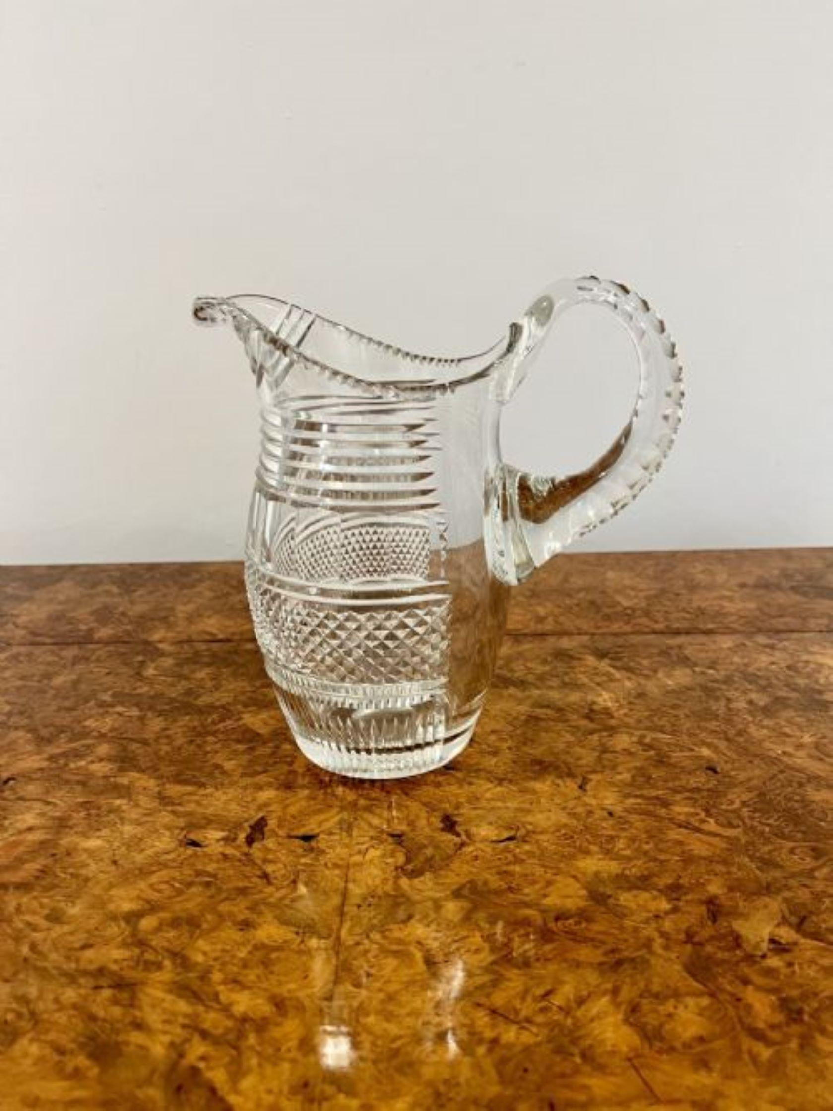 Superb quality antique cut glass water jug having a superb quality cut glass water jug with a shaped handle