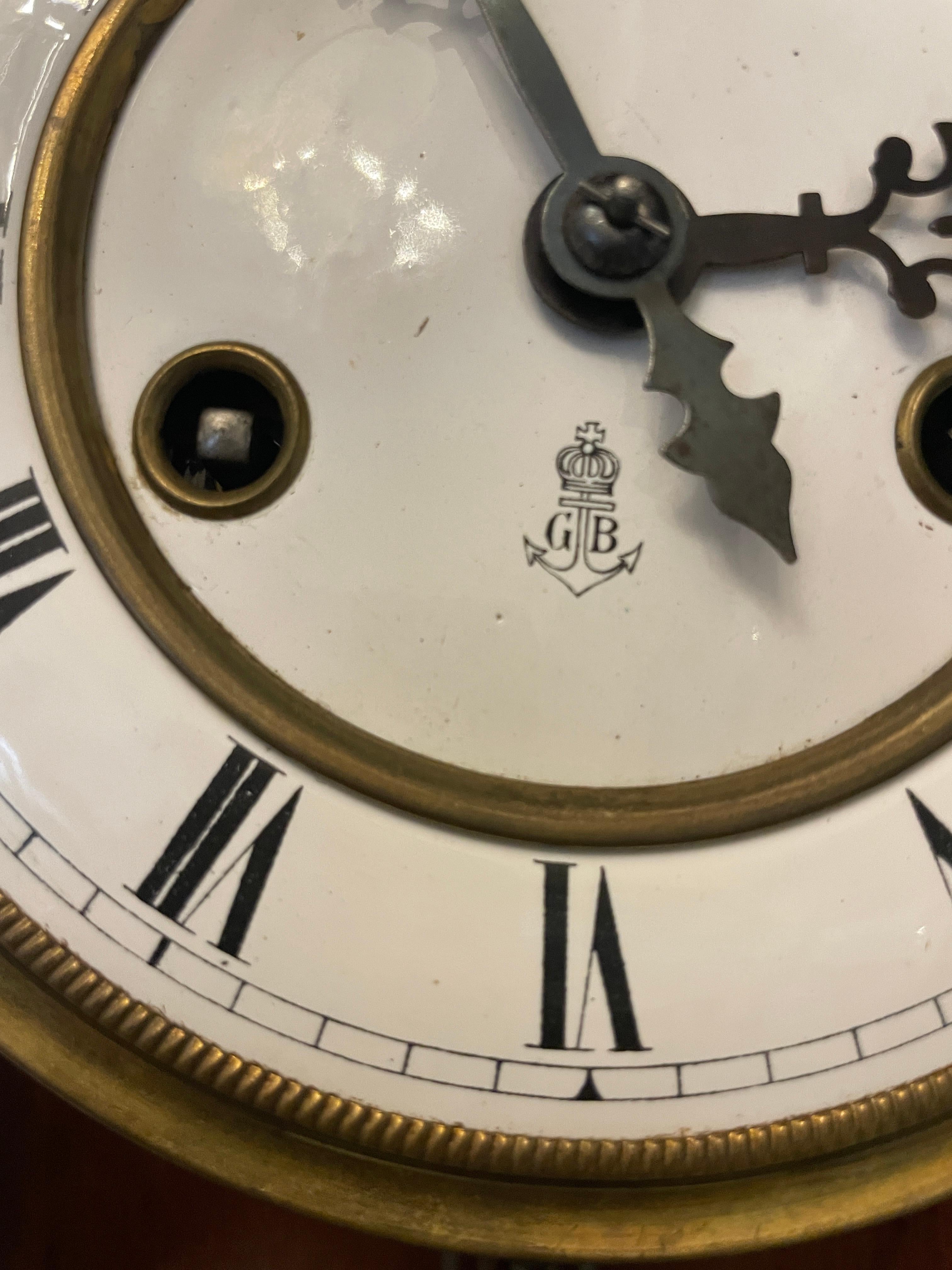 Espléndido reloj de pared antiguo de la Viena victoriana con tapa y base de nogal tallado de calidad, columnas de nogal torneadas en la puerta acristalada que se abre para revelar una esfera circular de porcelana con números romanos, agujas
