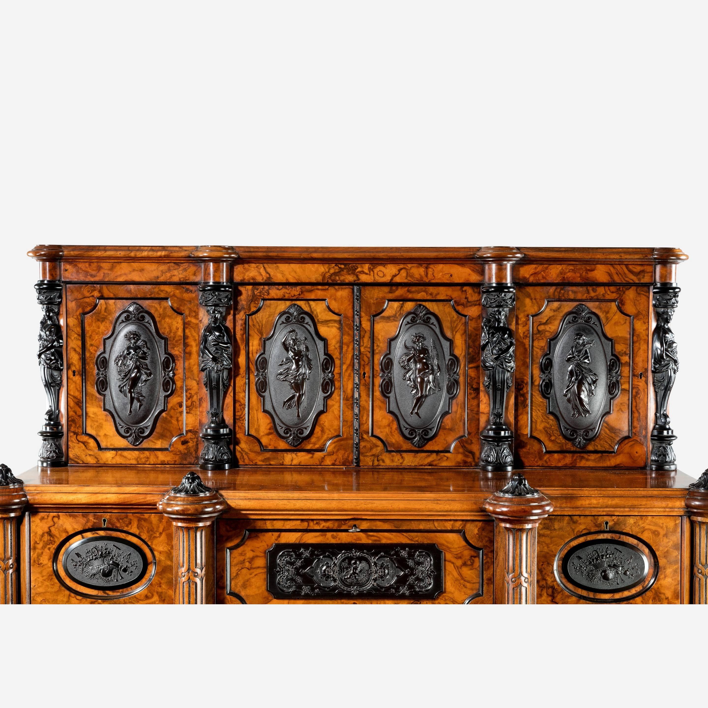 A superb quality burr walnut cabinet of upright rectangular form with three small drawers disguised in a frieze above three glazed cupboards between pilasters, the upper section comprising four smaller cupboards applied with black cartouches showing