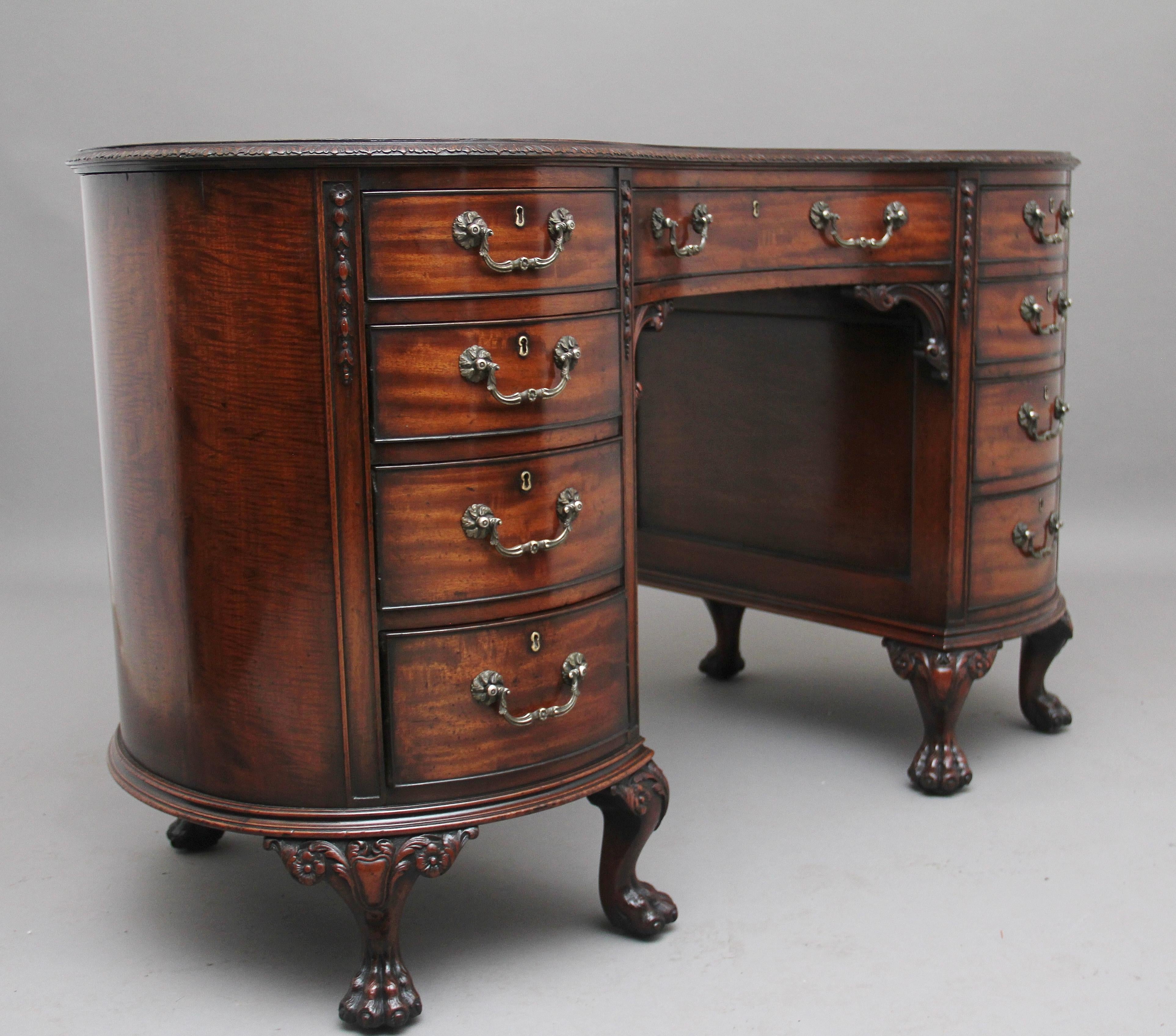 A superb quality early 20th century mahogany kidney shaped desk, the top having a green leather writing surface decorated with blind and gold tooling, lovely crisp carved and moulded edge above a selection of nine mahogany lined drawers with