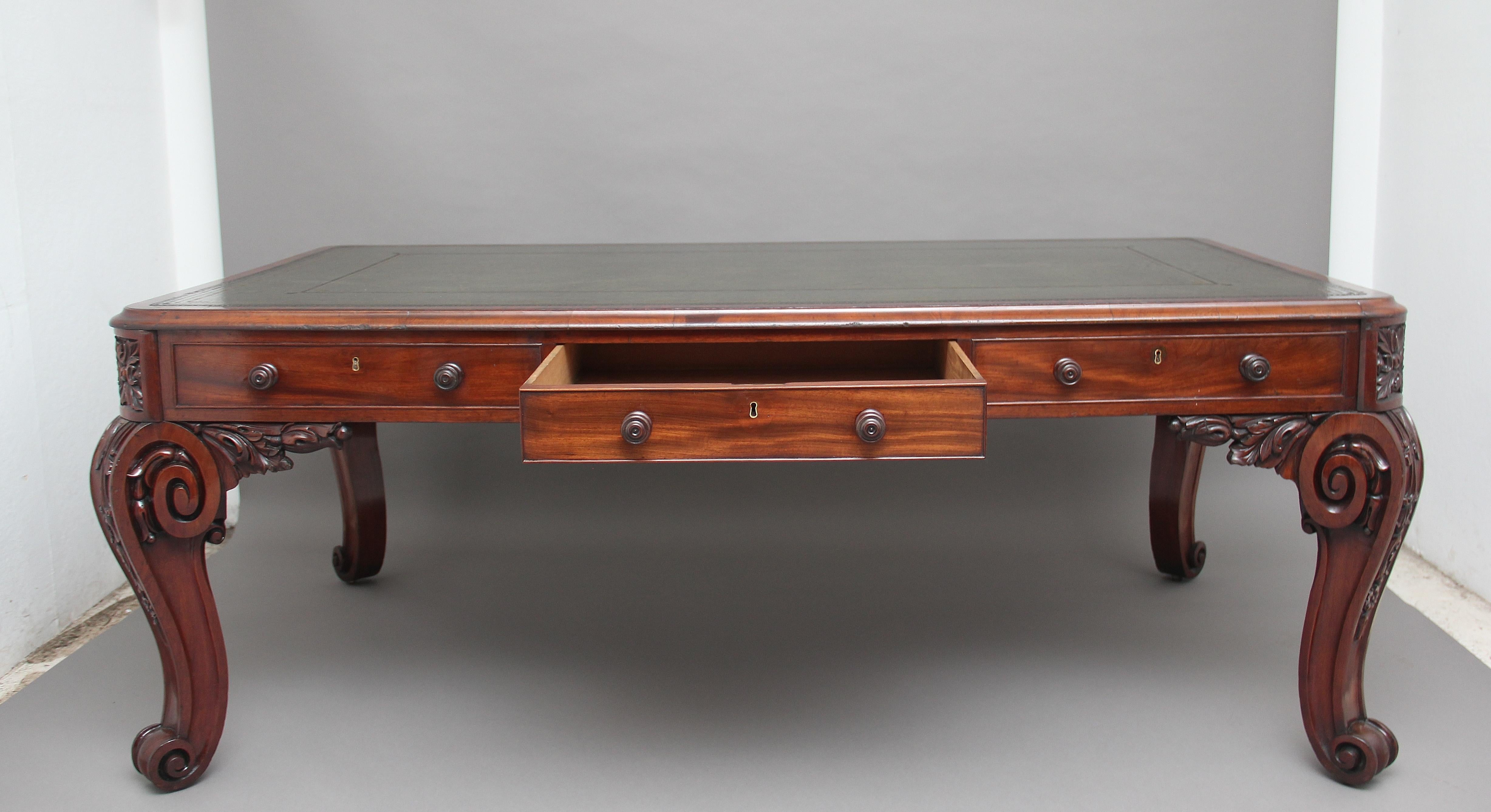 A stunning and important 19th century mahogany writing table / desk standing on four fabulous carved cabriole legs, on each side are two faux drawers and one working drawer in the middle, then on each end is a fitted drawer with a green leather