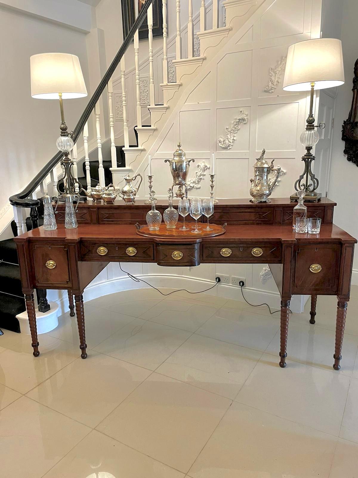 Superb quality large antique George III figured mahogany sideboard having a quality figured mahogany top with reeded moulded panels and sliding storage compartments above five drawers with reeded moulding and oval brass handles standing on six