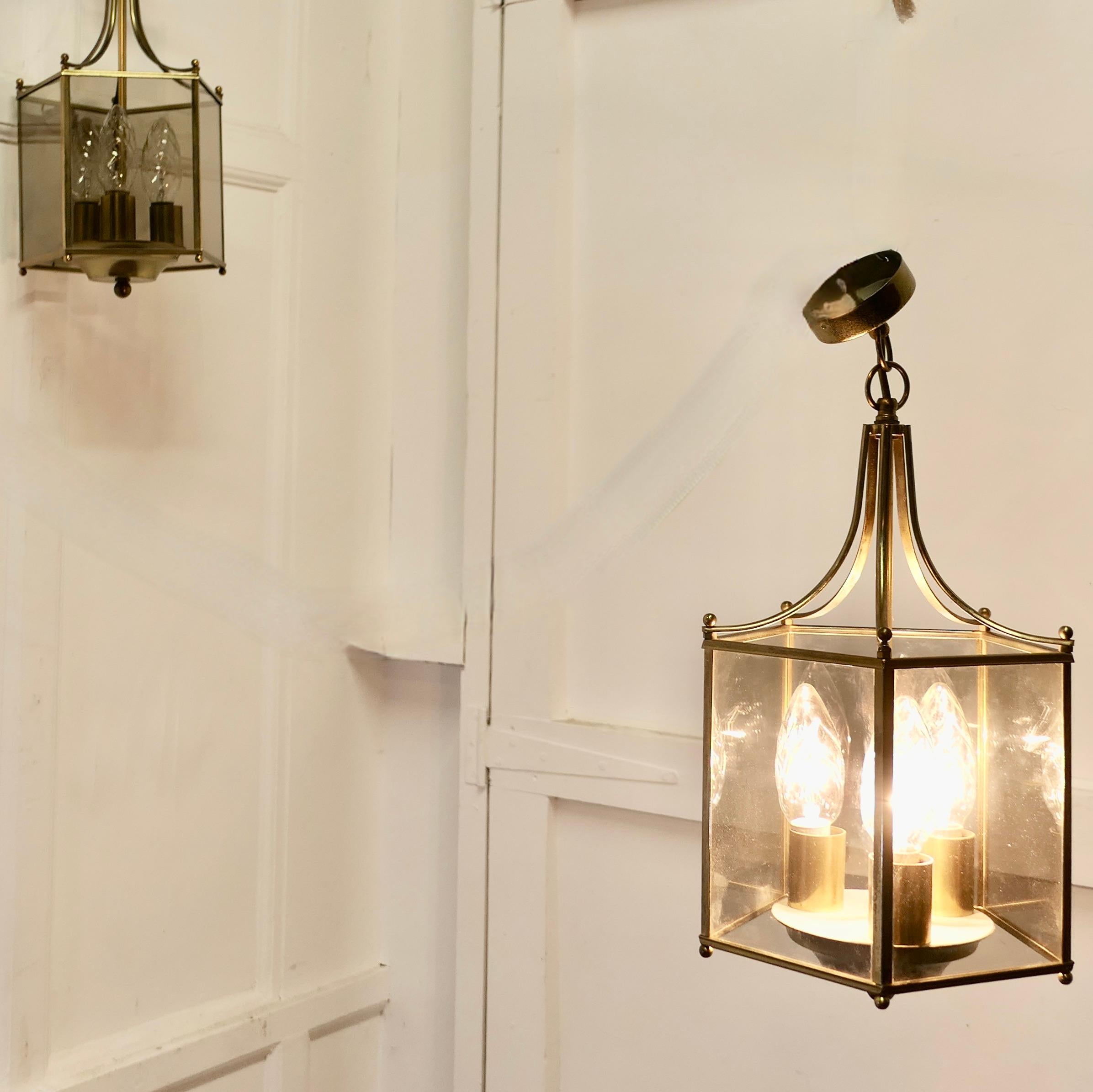 Superb Quality Pair of Art Deco Style Brass and Glass Lanterns  

These lovely lights have 5 flat smoked glass panels
The lanterns have a tripple candle sconce which gives a bright light when lit
The lantern frames are brass and hang from a rose  