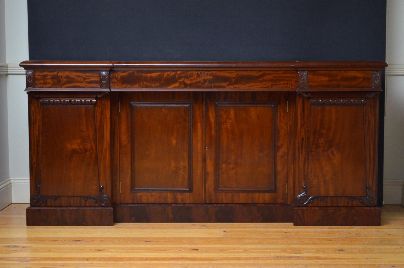 R00 Fine quality and very elegant William IV breakfronted sideboard in mahogany, having figured mahogany top above 3 oak lined drawers and flamed mahogany cupboard doors enclosing a shelf, all flanked by further panelled and carved cabinet doors