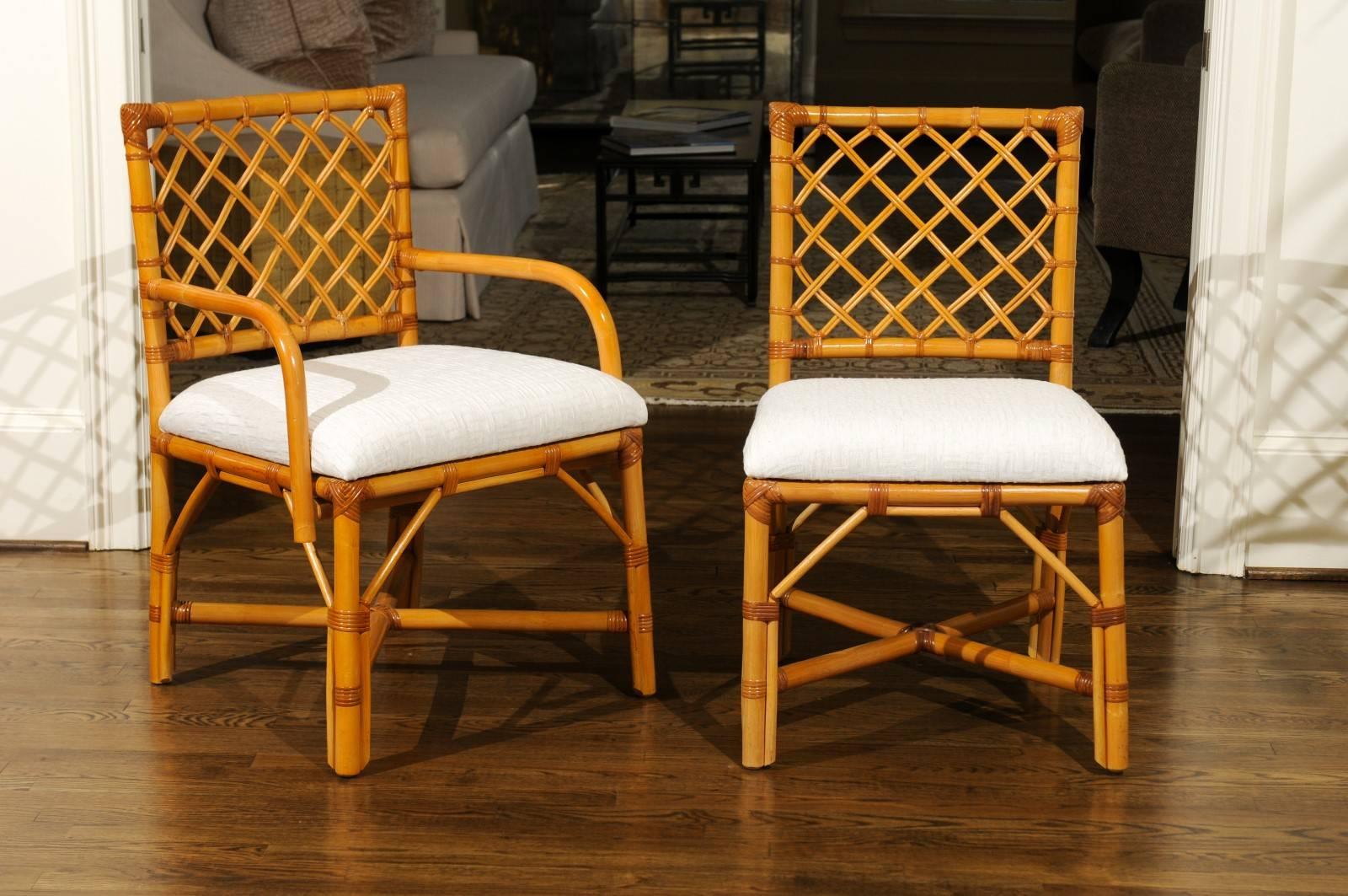 A beautiful set of eight (8) vintage dining chairs, circa 1975. There are two (2) host and six (6) side chairs. Expertly crafted rattan and hardwood construction with a lovely woven lattice back detail - mellowed to absolute perfection. Stout,