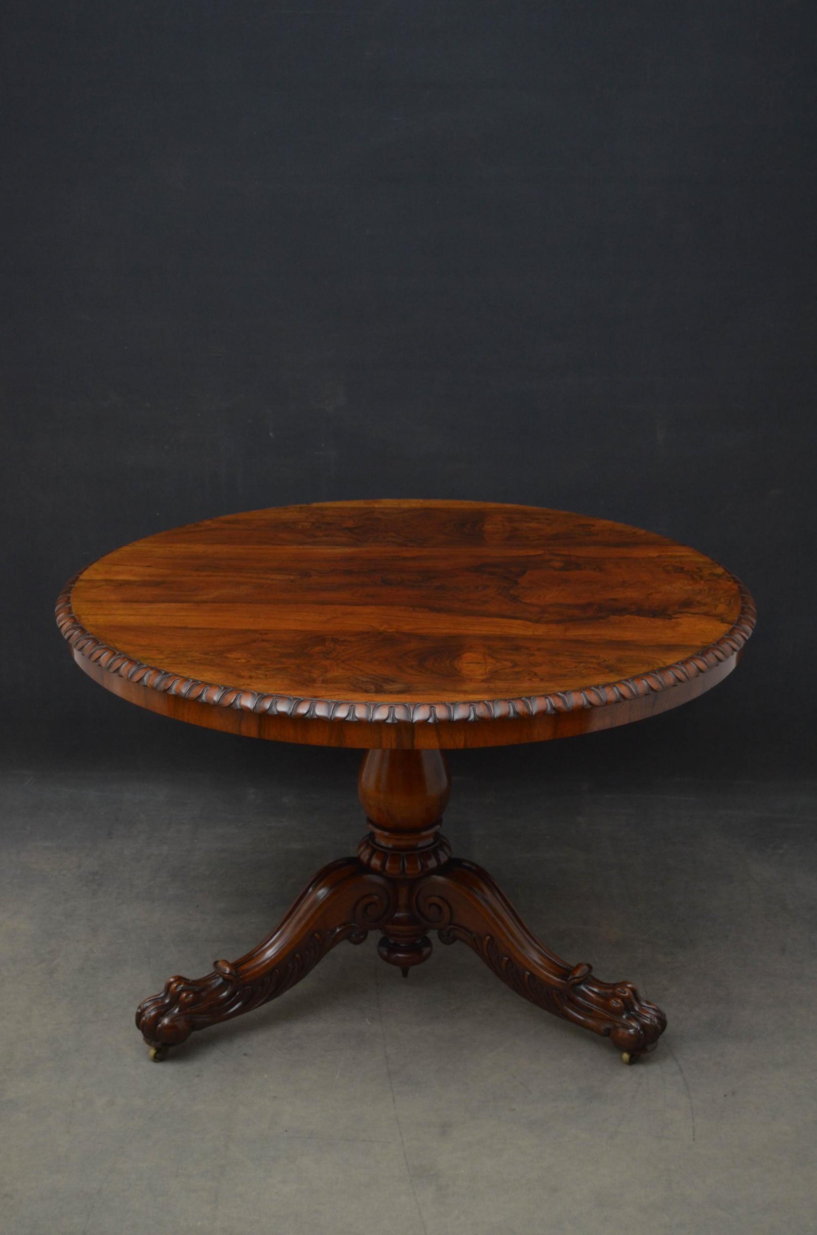 Sn5114 Fine quality 19th century centre or dining table in rosewood, having tilt top with fabulous grain and crisply carved edge, standing on vase shaped column with three finely carved, downswept legs terminating in paw feet in original castors.