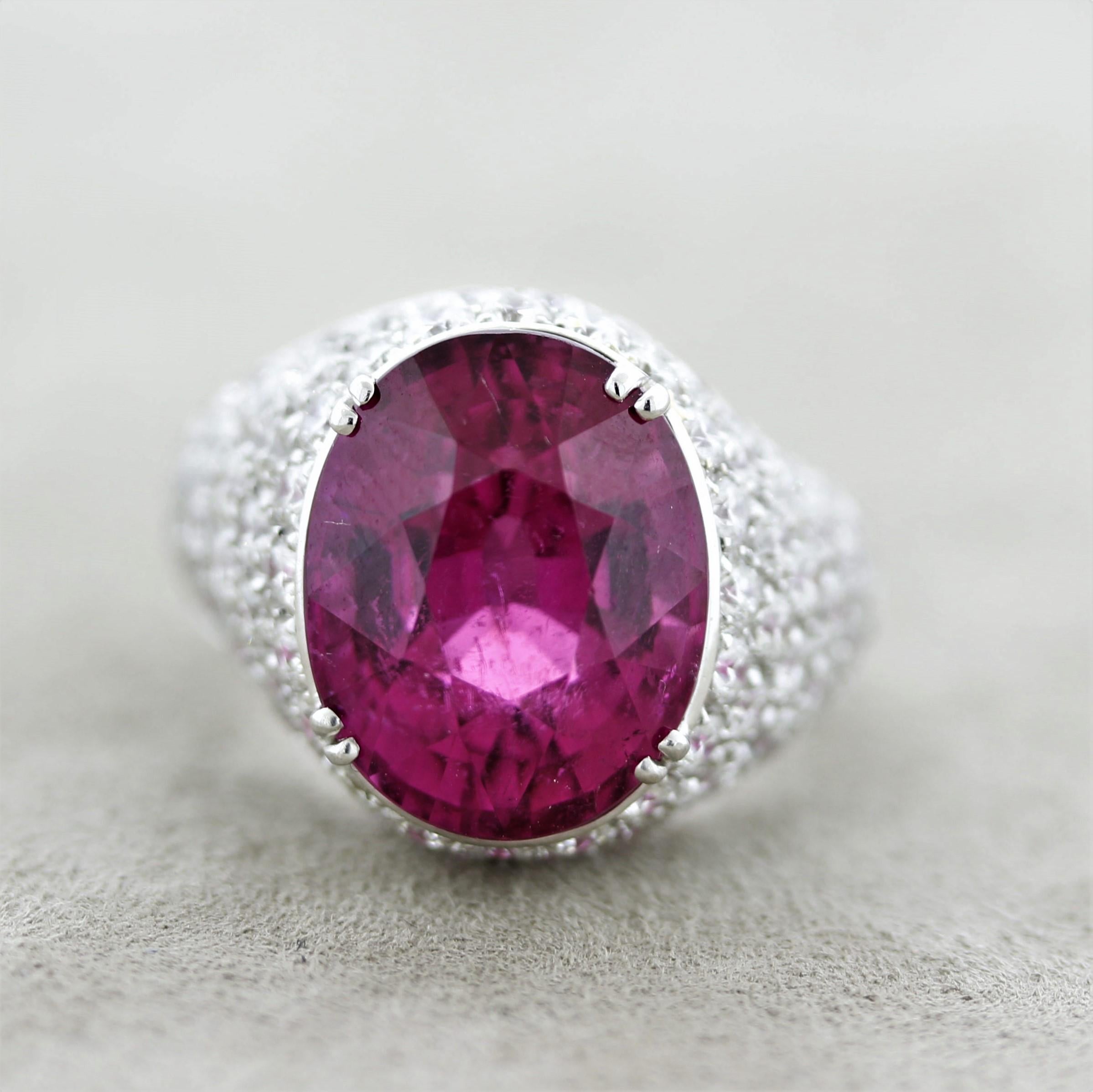 Simply amazing. This ring features a superb gem tourmaline with a bright and vivid red-pink color. It weighs 12 carats and has excellent brilliance and light return as the stone is eye-clean free of inclusions. A true rarity. It is accented by 3.45
