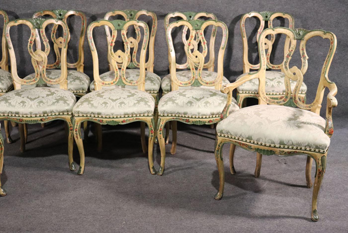 This is a rare set of antique Venetian paint decorated dining chairs from the 1930s era. They are beautifully painted and some have slightly different floral decorations. This set is strong and sturdy and each seat is upholstered in silk. The chairs