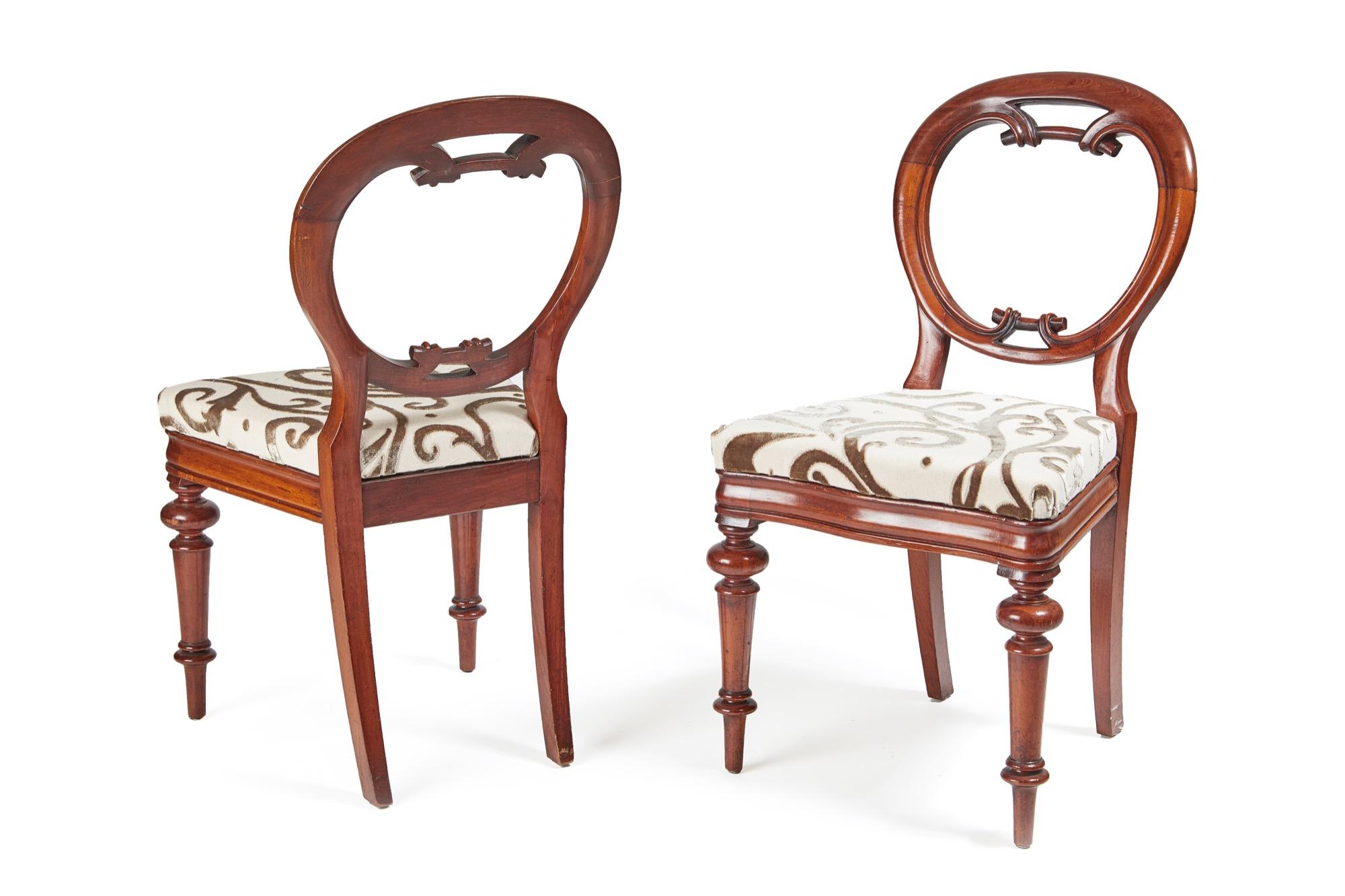 These are an outstanding set of six 19th century Victorian antique mahogany balloon back chairs. The circular backs have a beautifully carved lower rail and they stand on elegant turned fluted legs to the front and out swept back legs. The drop in