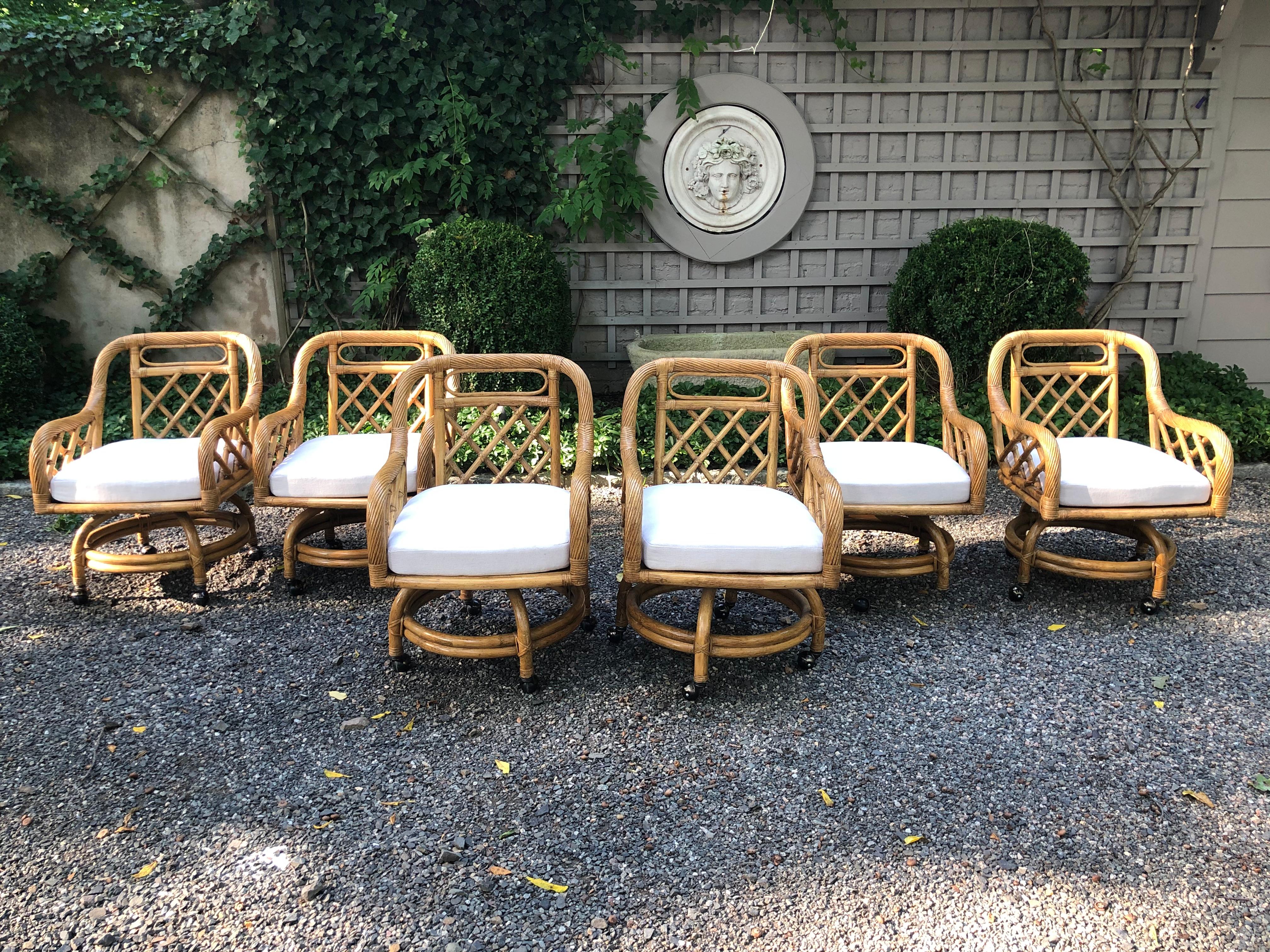 Fabulous set of six Mid-Century Modern rattan swivel dining chairs in the style of Franco Albini. Each chair has an off white linen loose cushion. These chairs have a chunky appearance and are quite substantial.
Measures: Seat height 18.5”, arm