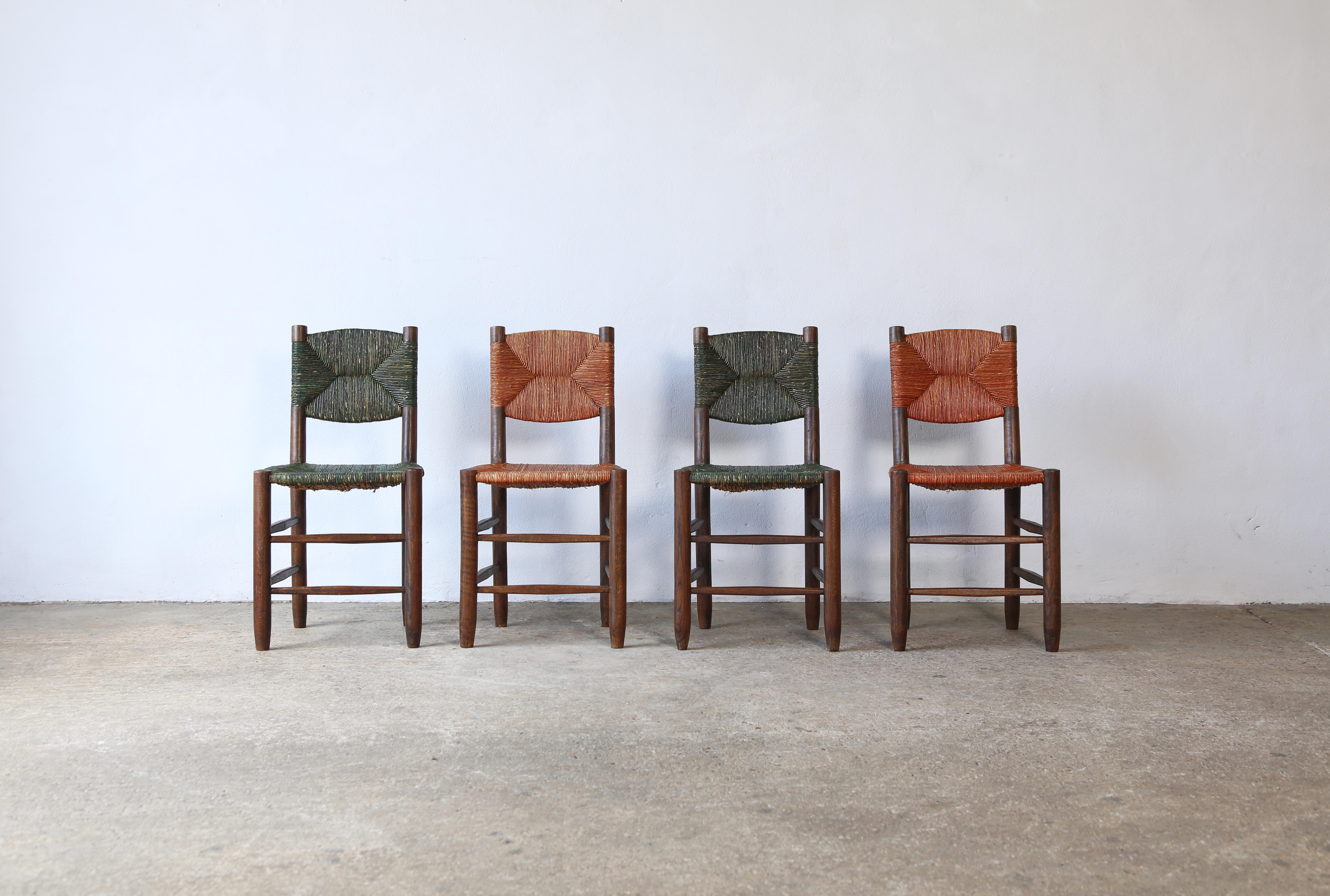 Una superba coppia di sedie Charlotte Perriand Model 19 Bauche, Francia, anni '50, con rarissimi cordoni color verde e ruggine. Questi esemplari sono stati prodotti molto probabilmente dal maestro ebanista Andre Chetaille presso Steph Simon. In