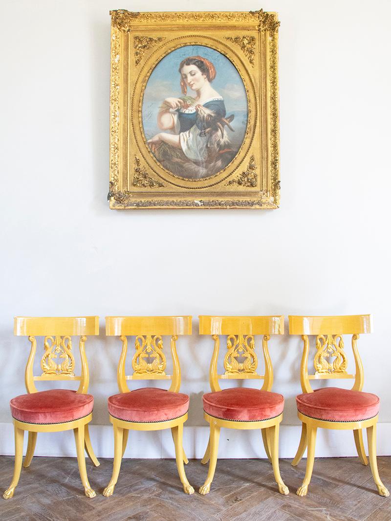 Très intéressant ensemble de 4 chaises italiennes en bois laqué or jaune. Dossier de chaise Lyres avec deux licornes face à face au centre, dont certaines parties sont dorées. Les pieds se terminant en pattes de lions sont également dorés. L'assise