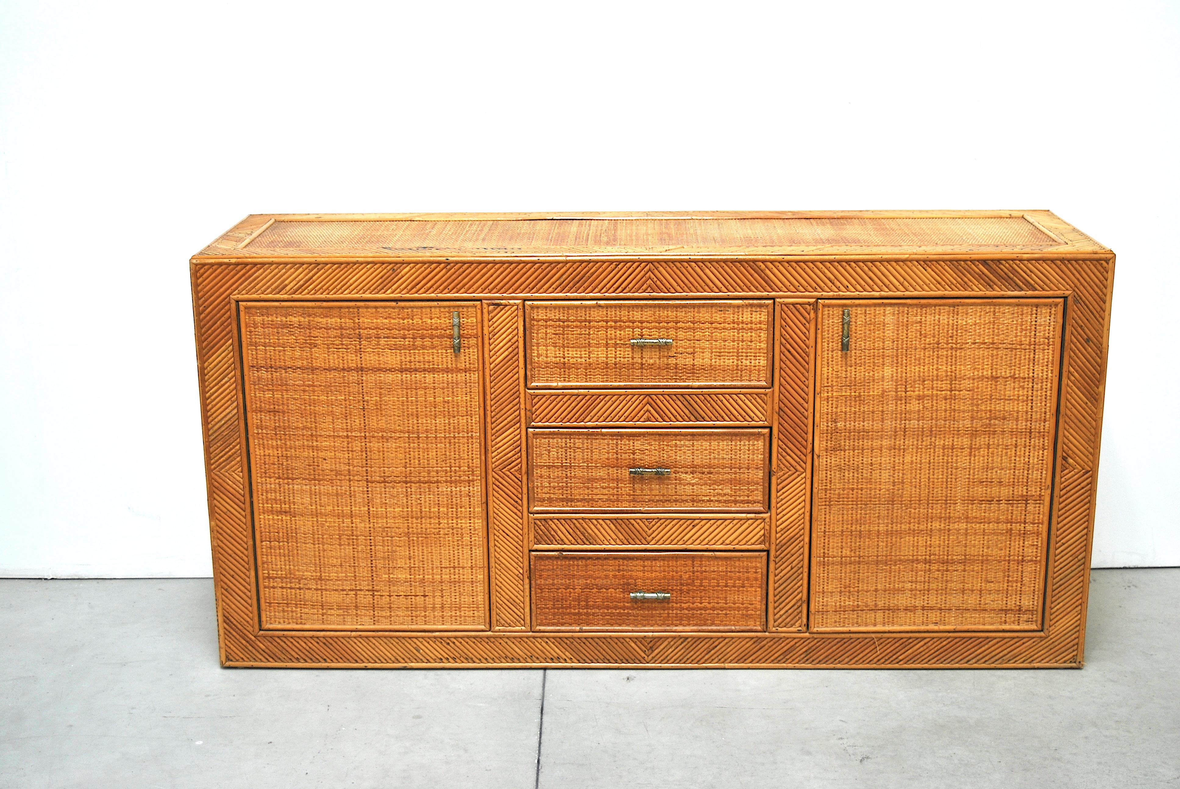 Italian production early 1970s sideboard in rattan embellished with brass handles, in the style of the famous Milanese designer Gabriella Crespi.