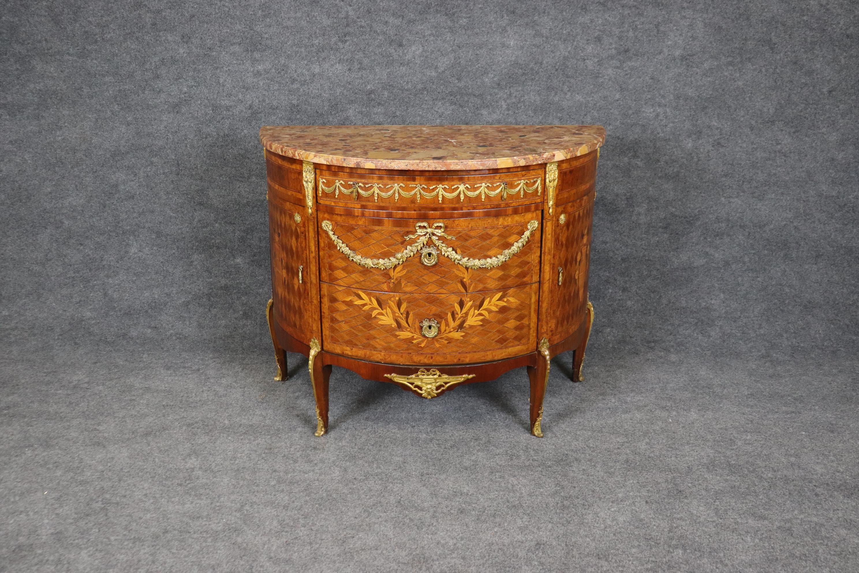 Cette éblouissante commode en bois satiné et noyer incrusté est ornée de splendides fleurs naturalistes en bronze doré et d'une solide plaque de marbre très prisé de la Brèche d'Alep sur le dessus. Pour ceux qui ne le savent pas, ce marbre