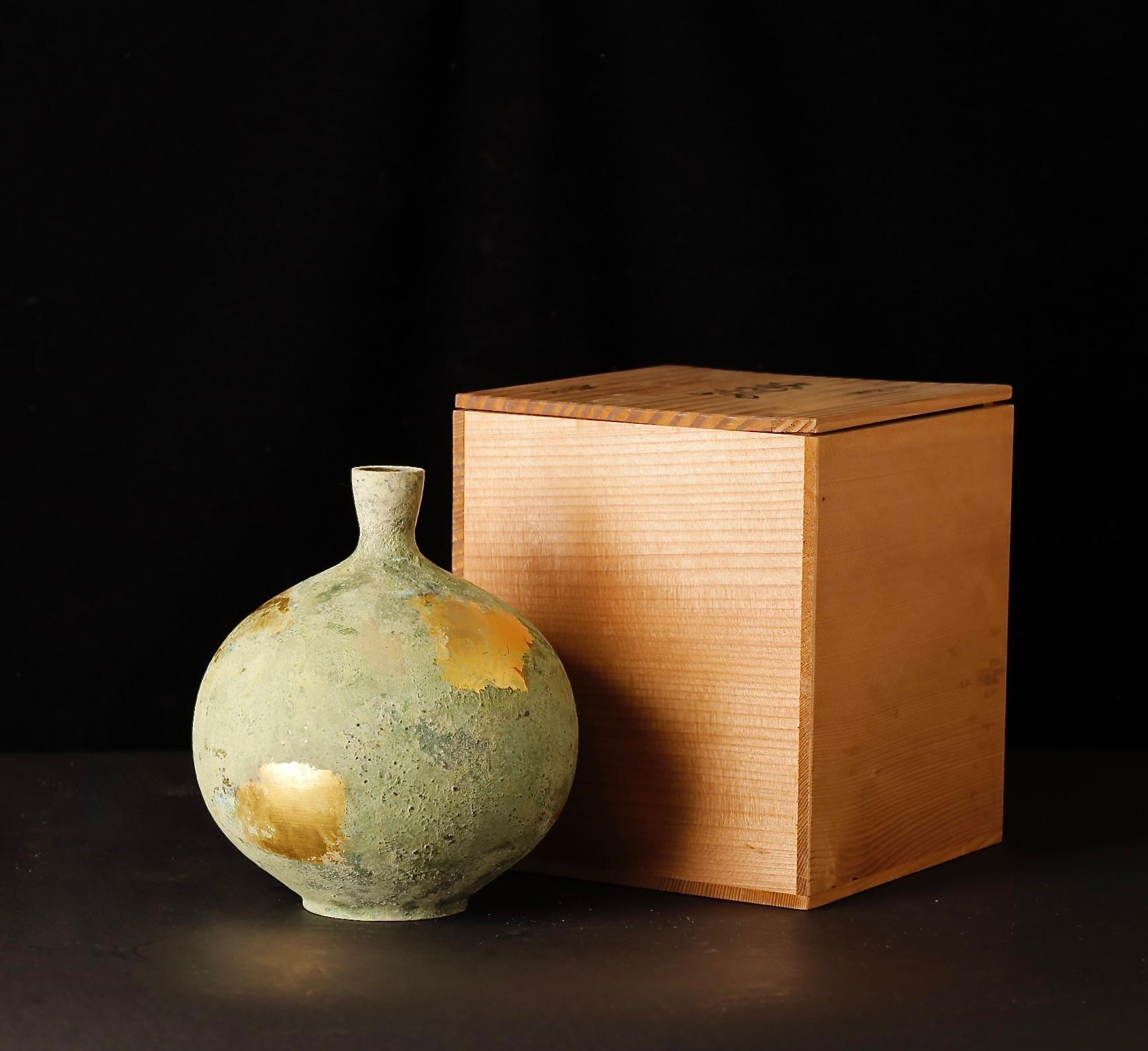 Un vaso in bronzo giapponese raffinato e superbamente fuso, firmato dall'artista Isao e accompagnato dalla sua scatola di legno originale firmata. Realizzato durante il periodo Showa (XX secolo), il vaso presenta una forma forte ed equilibrata e una