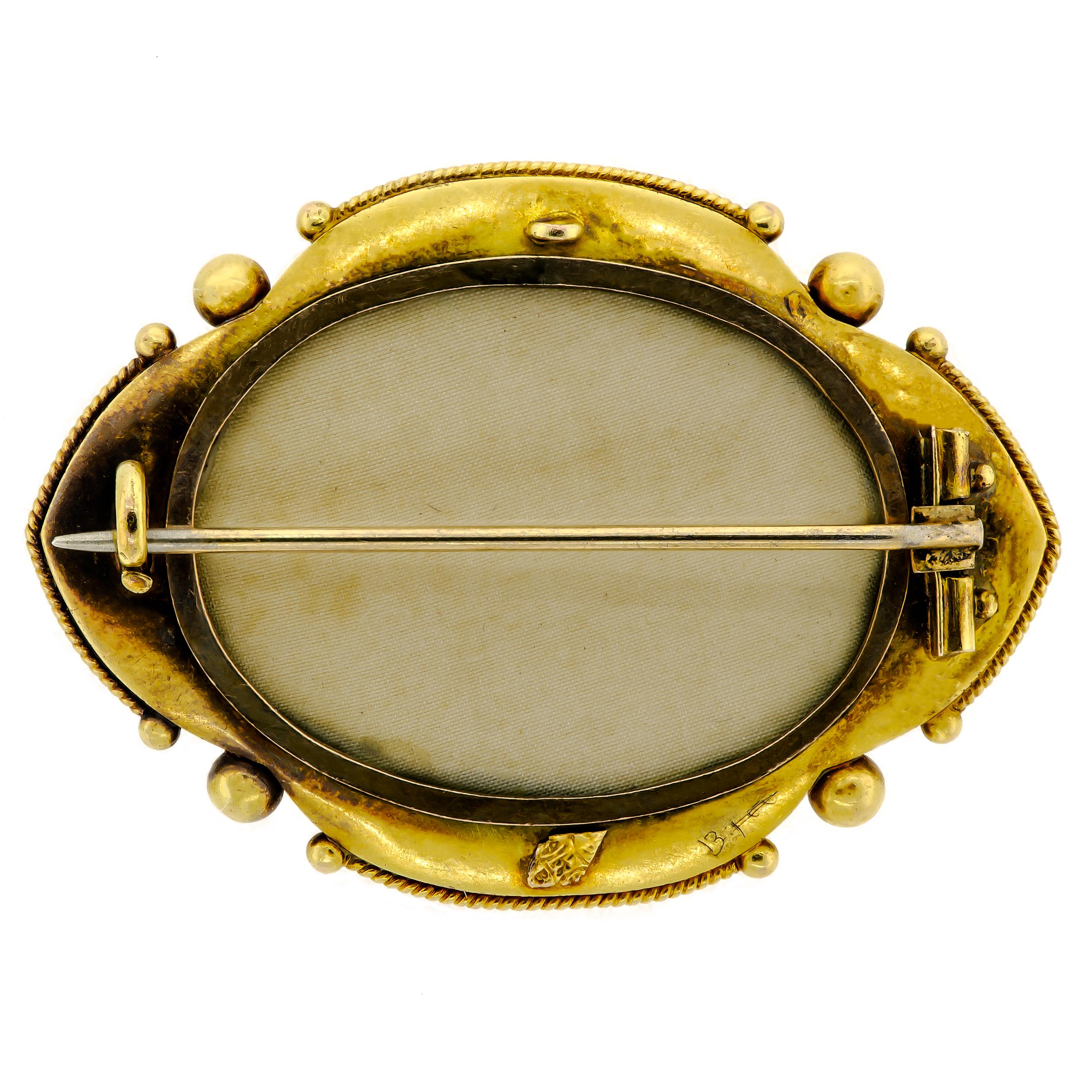 This stunning antique Victorian brooch is a true masterpiece of jewelry design. It is made of 14kt yellow gold, which gives it a warm, golden glow. The brooch features a locket compartment on the back that is adorned with numerous pearls and a small