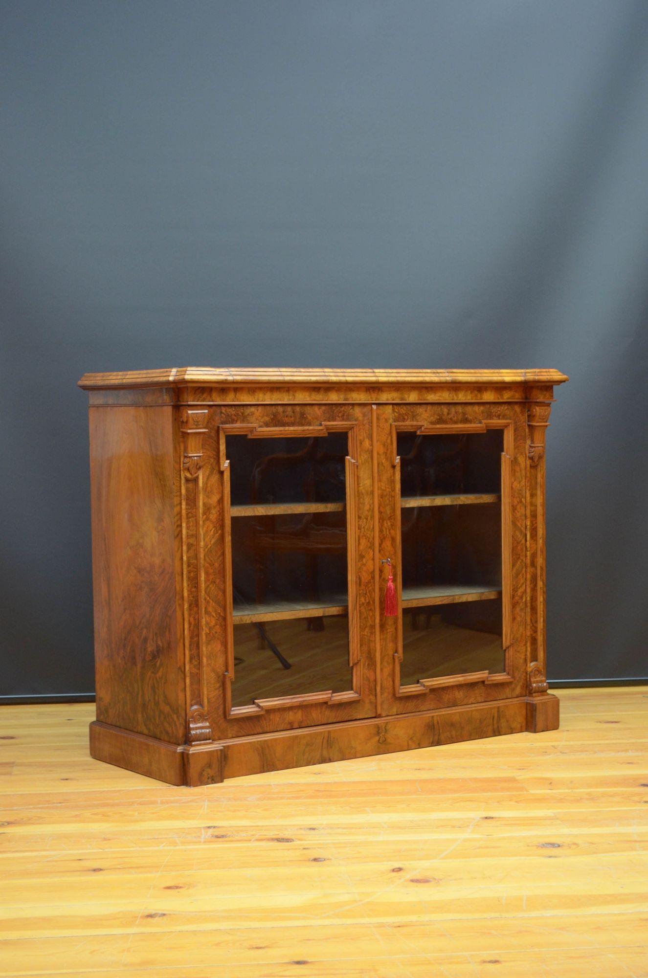 Sn5353 Libreria o vetrina vittoriana in noce di qualità e molto attraente, con piano in noce figurato sopra una coppia di ante vetrate che racchiudono un interno originale foderato con due ripiani e dotato di serratura originale funzionante e