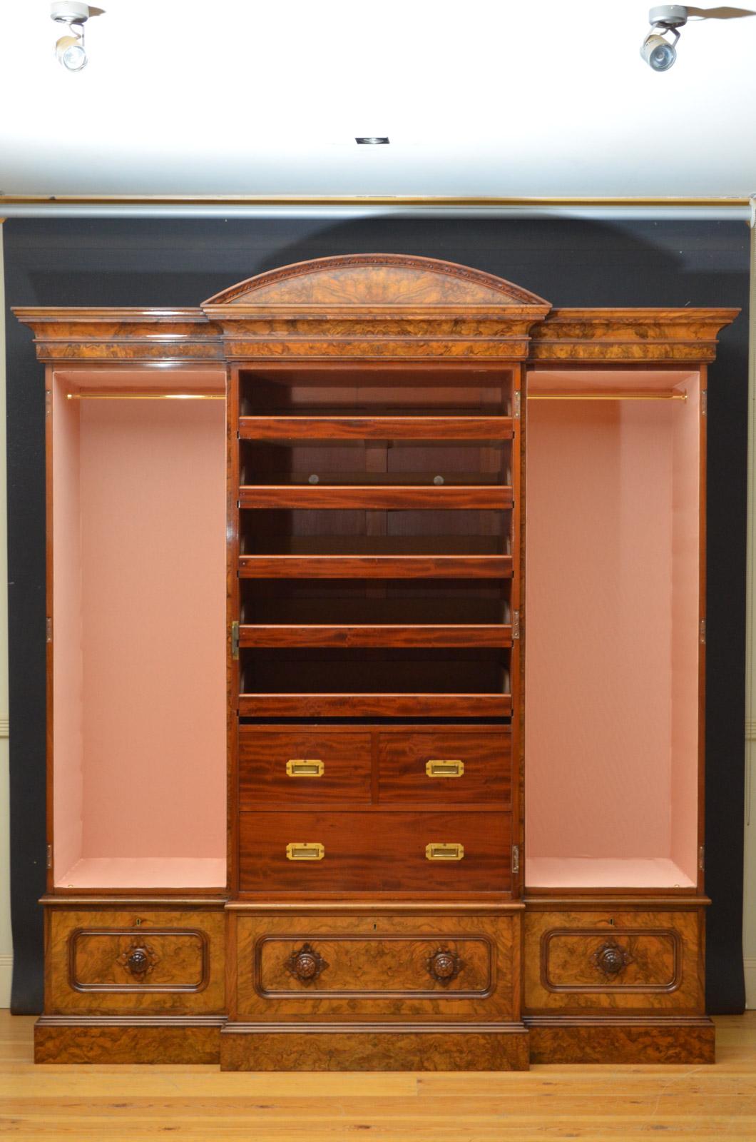 Sn4387, exceptional Victorian, three-door wardrobe in burr and figured walnut, having arched and flower carved pediment with molded cornice above projecting mirrored door with fine carved decoration to corners, flanked by paneled, arched cupboard