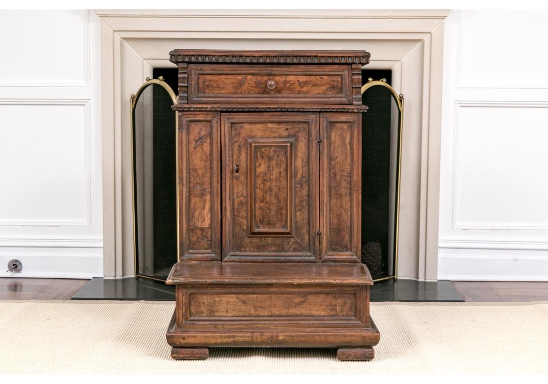 A rare and extraordinary Louis XVI style Walnut Kneeler dating to the mid 1700’s and likely Italian. Monolithic in form, the Cabinet features inset drawer, side  and door panels with handsome burling, simple turned drawer pull, dentil type trim and