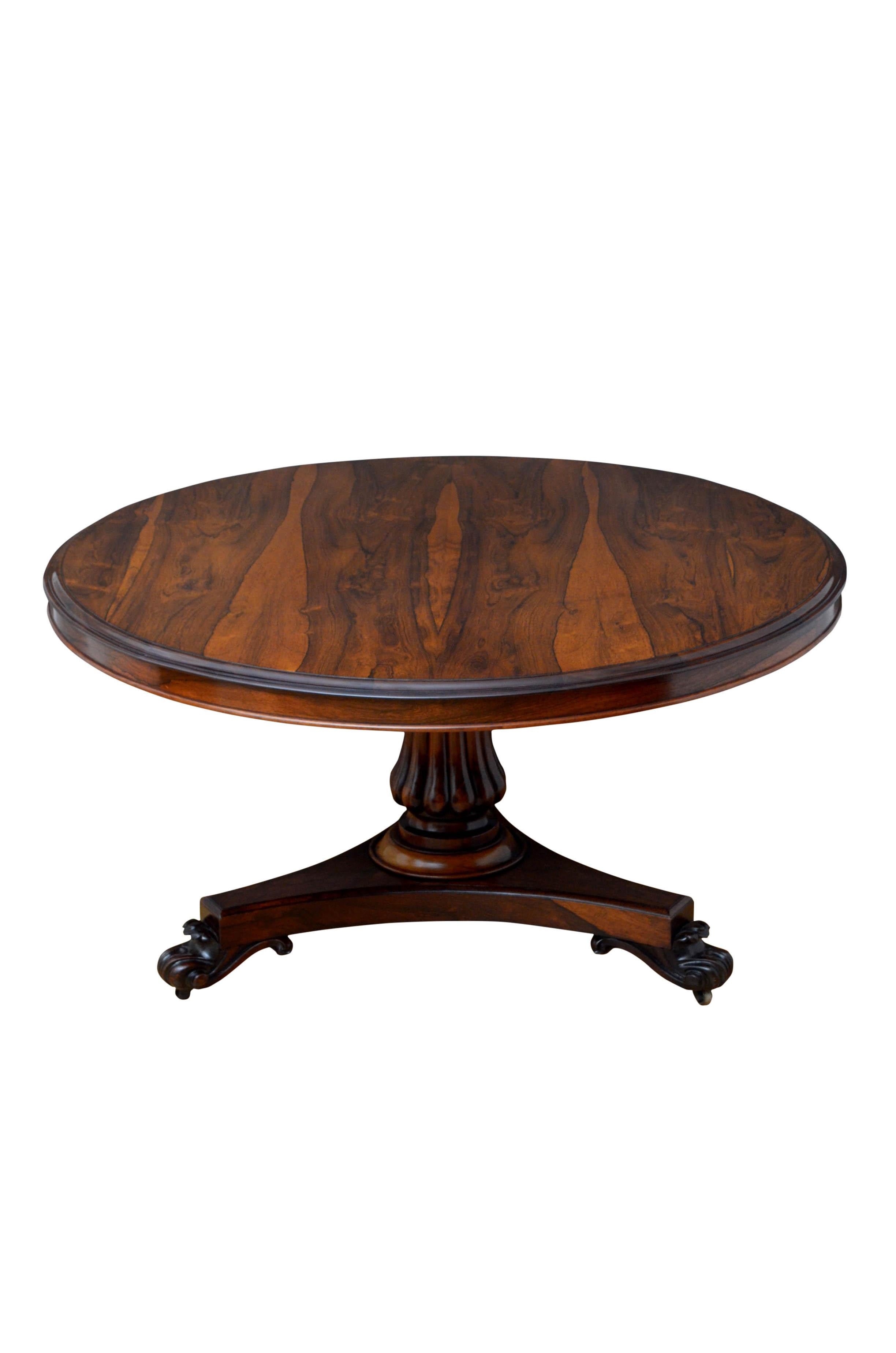 K0486, exceptional William IV, tilt-top breakfast table or center table in rosewood, having stunning grain to the top above shallow frieze, raised on a vase shaped, fluted column terminating in trefoil base, finely carved scroll feet and brass