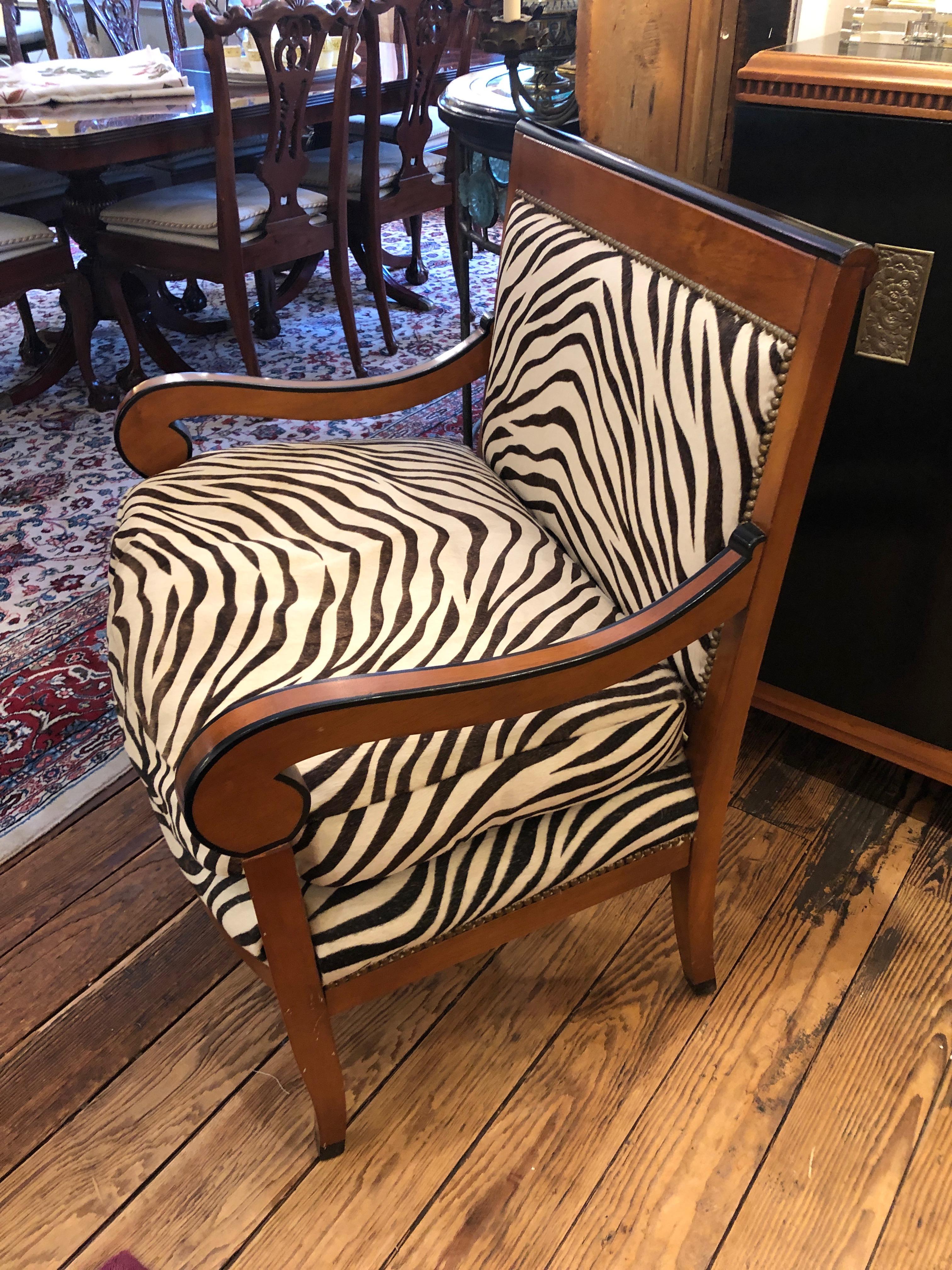 A fabulously chic oversized club chair having Biedermeieresque bird's-eye maple and ebonized frame, upholstered in real cowhide printed in a zebra pattern. Seat cushion is down filled and super comfy.