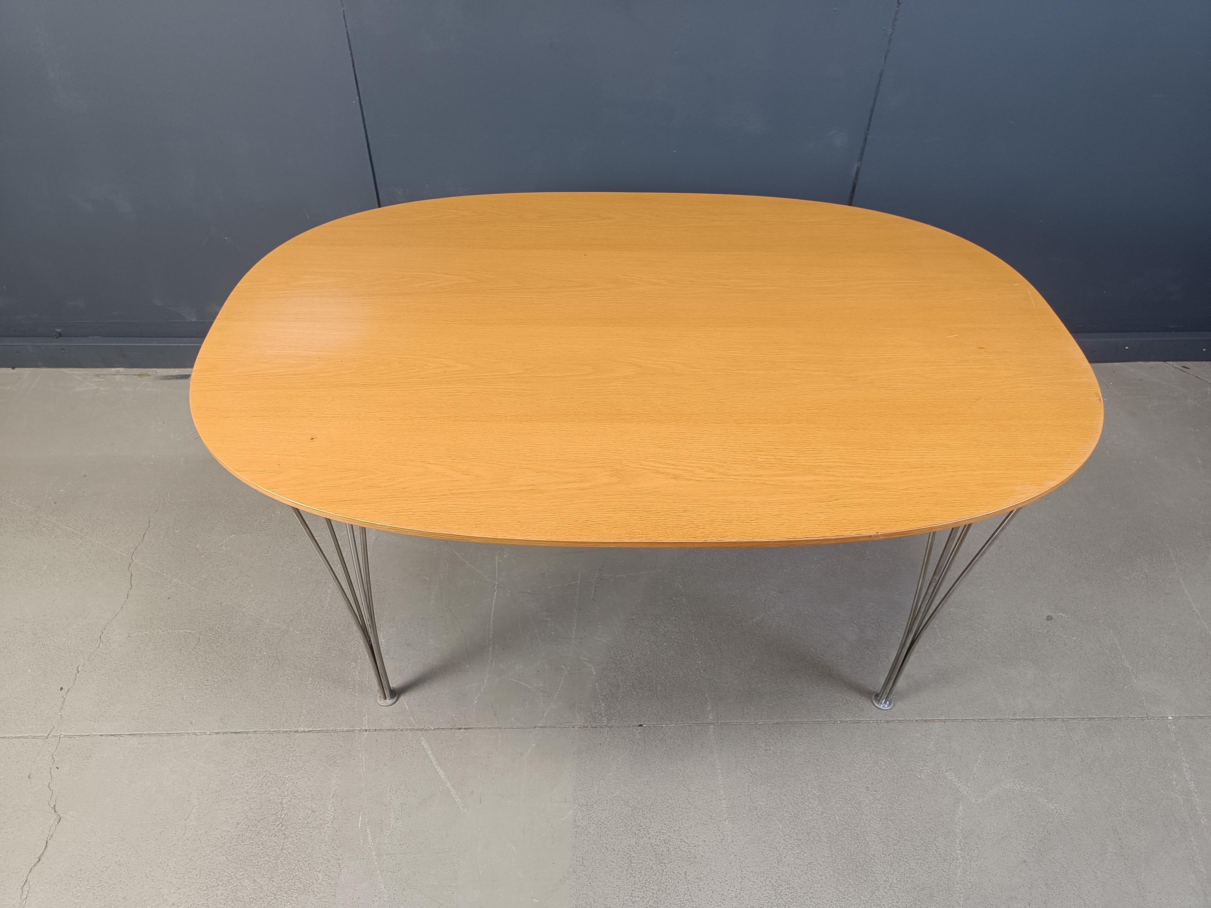 Vintage superellipse dining table designed by Bruno Mathsson and Piet Hein in the 1960s for Fritz Hansen.

The table has been produced eversince.

This one is dated 2007.

Fine and elegant chrome wire legs and a lacquered beech wooden table
