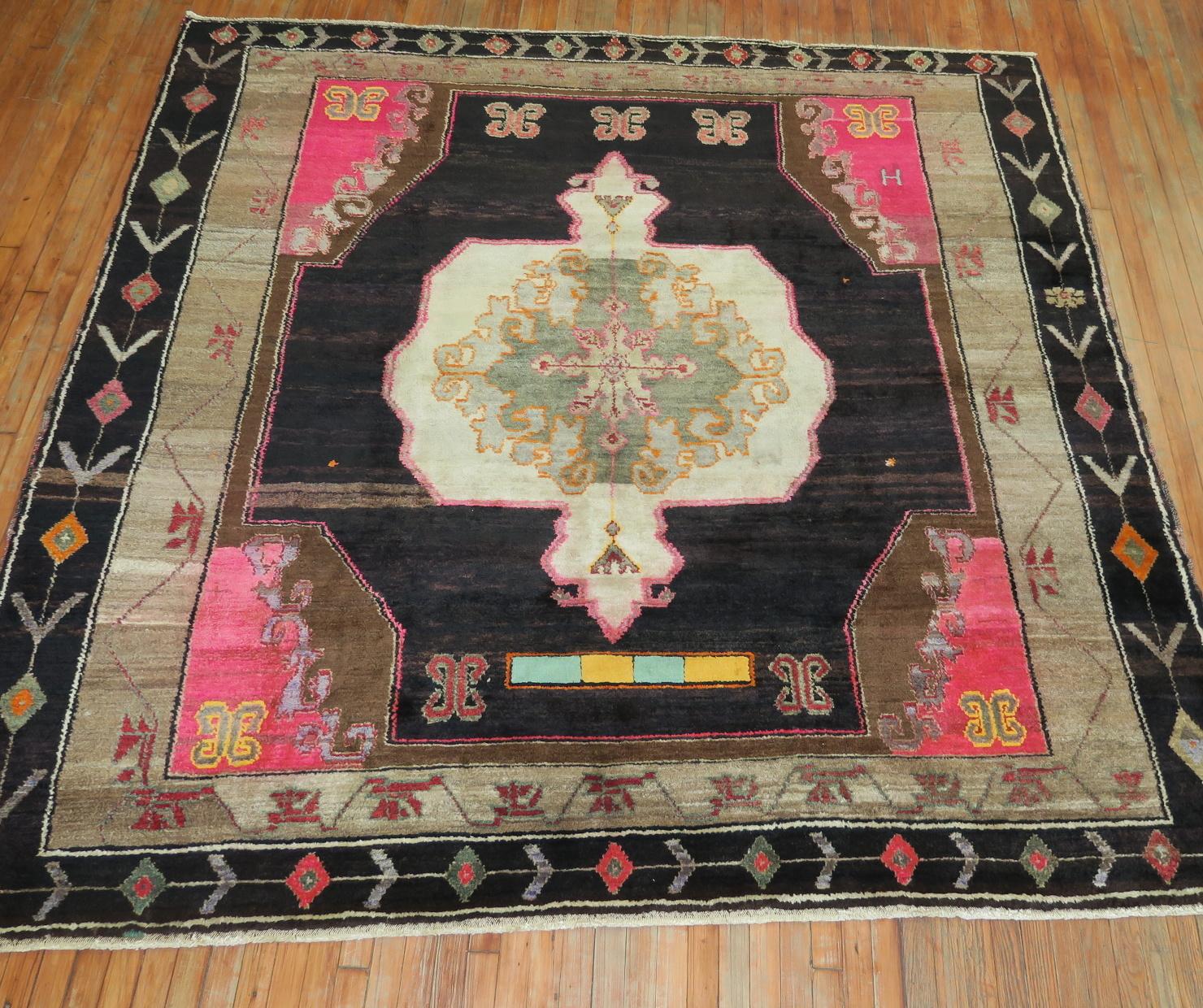 A wild 20th century Turkish Kars square size rug. A large scale floral design featuring a white medallion on a dark brown field, accents in bright pink with a geometric border. Looks like it’s been barely used. Previous owner must have used it in