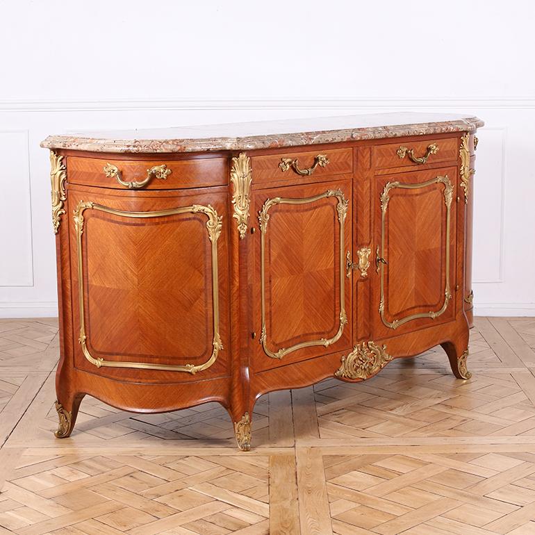 Cet exceptionnel buffet de style Louis XV du début du XXe siècle en bois de roi richement veiné est un exemple exceptionnel de l'artisanat français et du style rococo. Elle se compose de panneaux à losanges inversés dans des cadres ornés de bronze