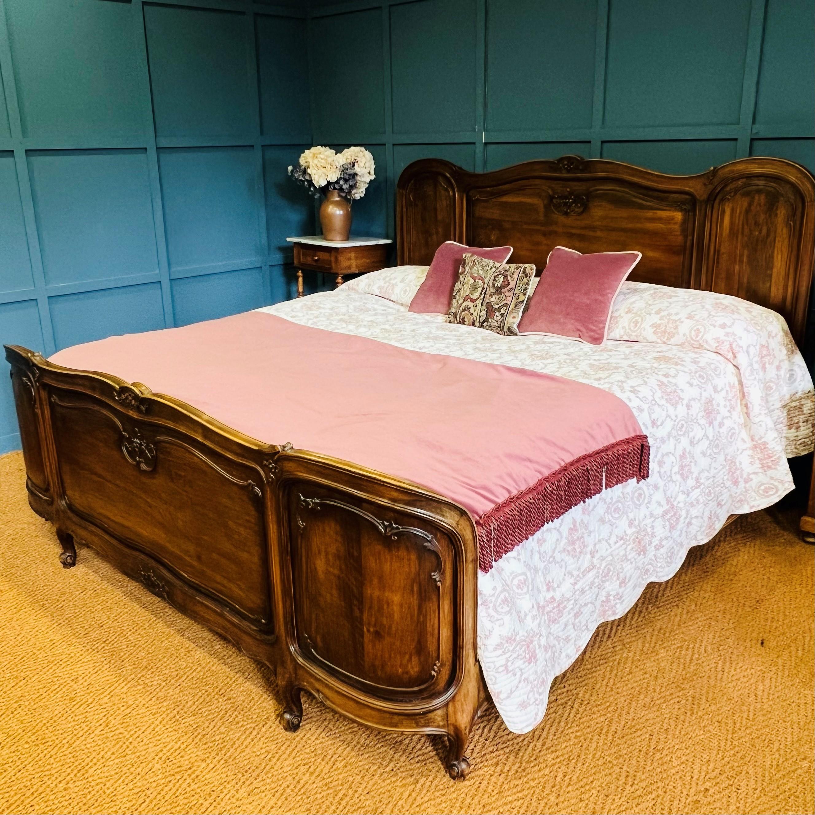 This handsome extra large antique French bedstead measures in at over 6’ (200cm) wide. Made of walnut, with a demi corbeille foot end and detailed carvings arranged within decorative panels, it is sure to make a statement in its new surroundings..
