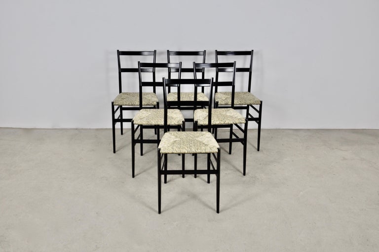 Set of 6 black wooden chairs, wicker seat. Wear due to time and age of the chairs, small marks on the corners (1950s, see pictures). Measures: Seat height 47cm.