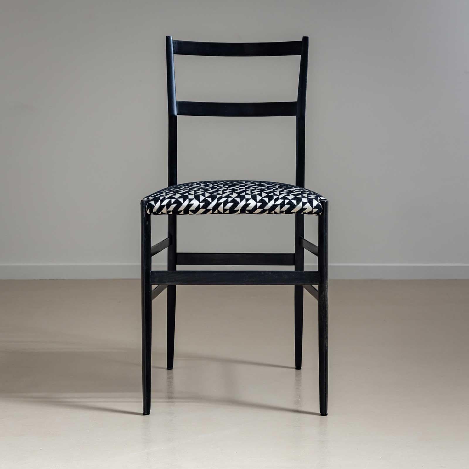 Set of seven side chairs, model Superleggera, designed by Giò Ponti in 1957. The chairs are made of dark stained wood with a smooth polished finish and the seats have been reupholstered. The black and white fabric has a geometric pattern and the
